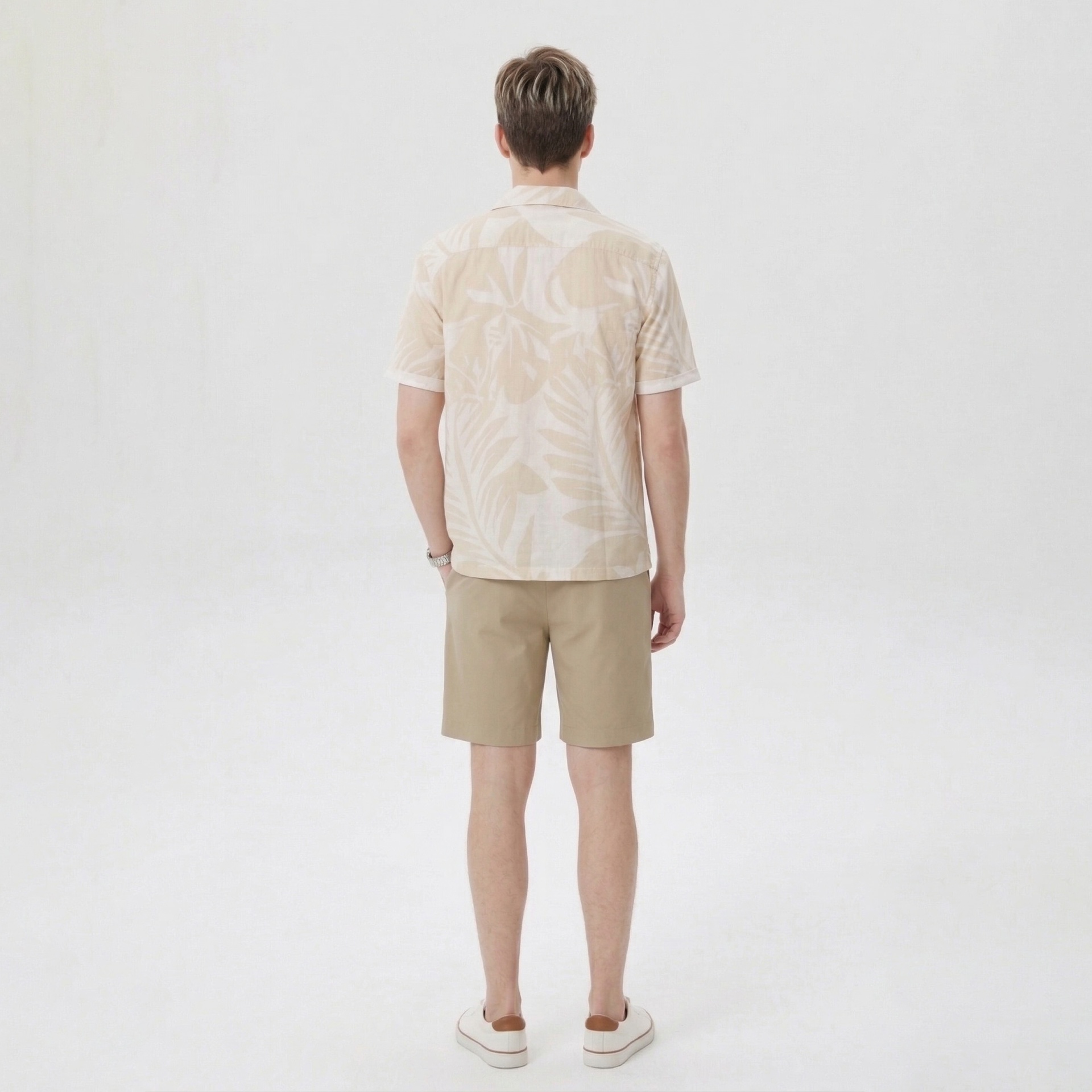 Homem de costas com camisa bege e calções bege