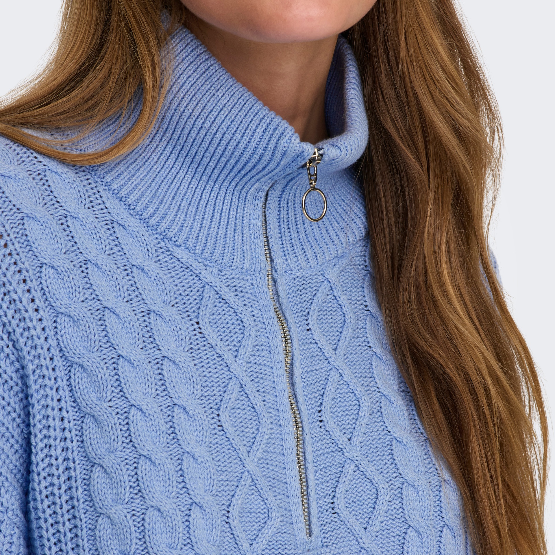 Camisola de malha azul clara com gola alta e fecho