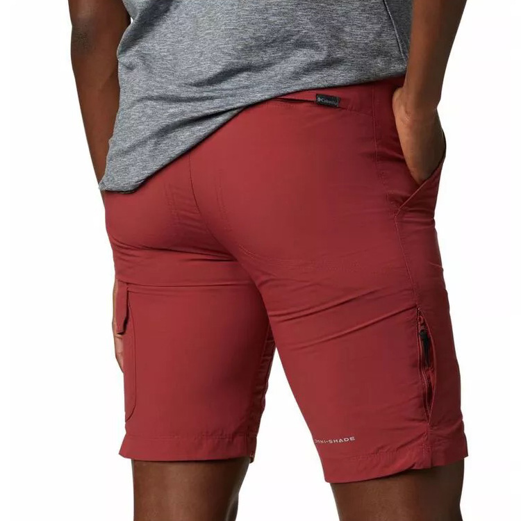 Calções vermelhos Columbia com bolsos e fecho, usados por homem com t-shirt cinza