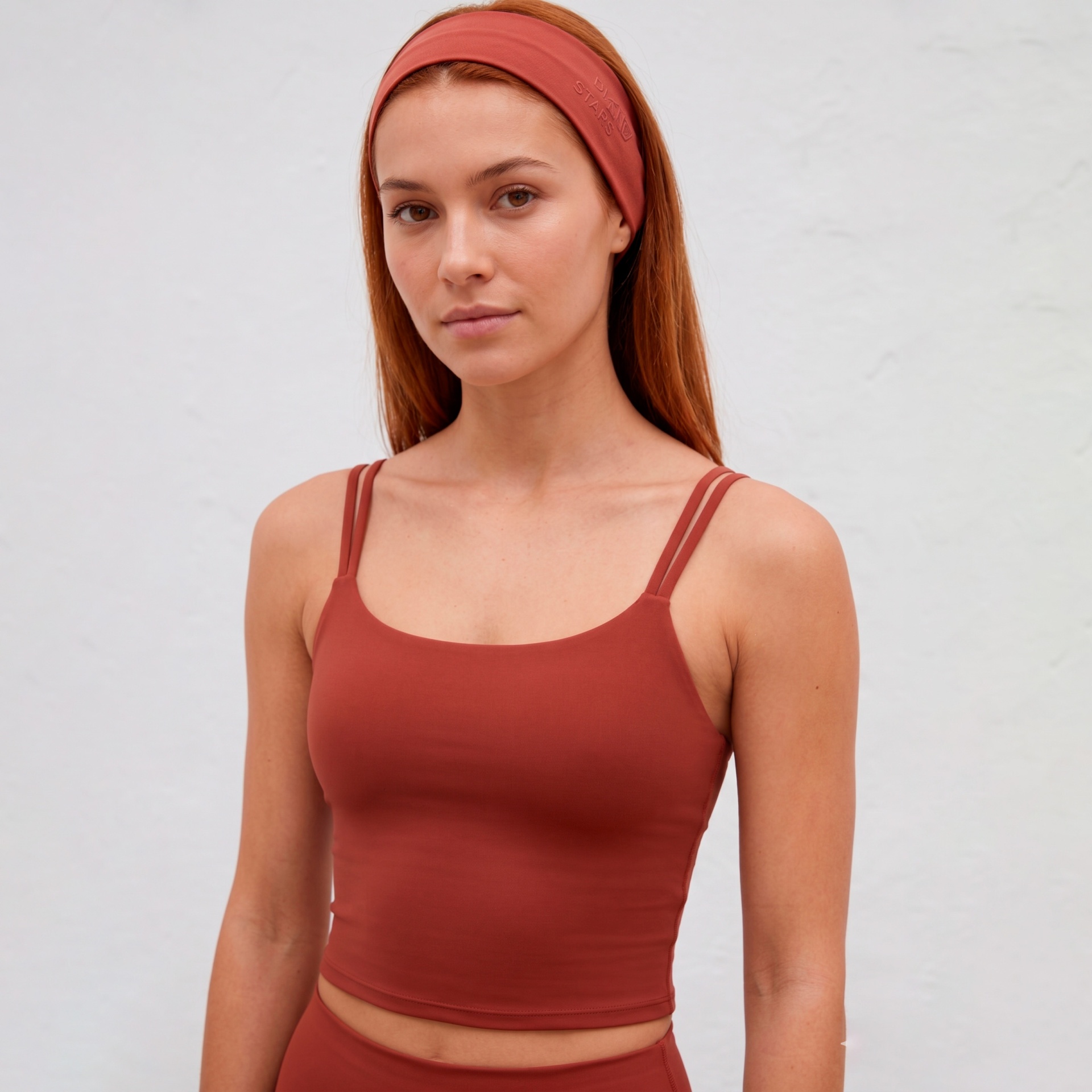 Mulher a usar top cropped e faixa de cabelo cor terracota