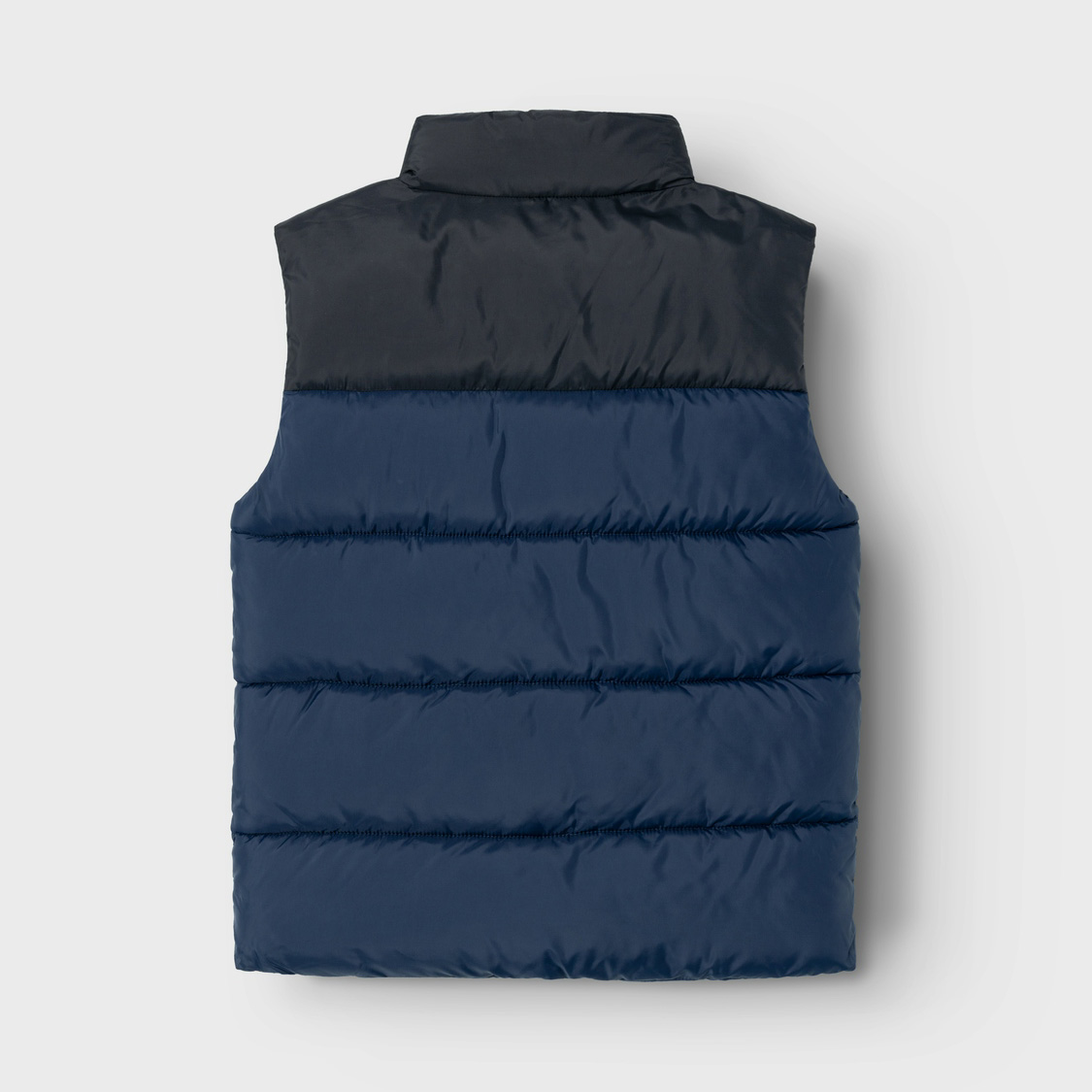 Colete acolchoado azul escuro e preto contra fundo branco