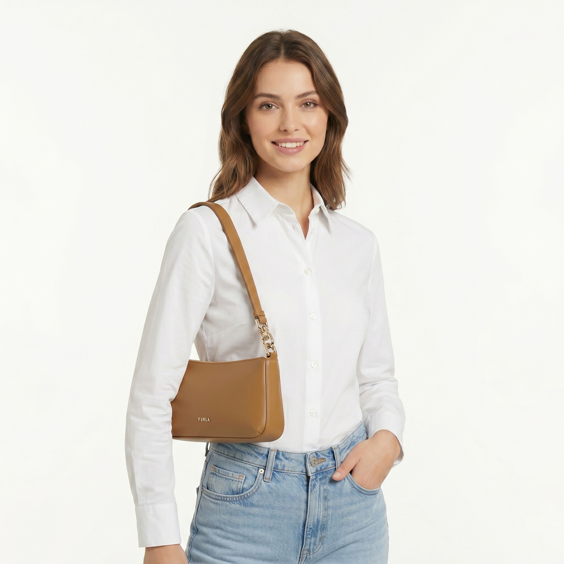 Mulher com camisa branca, jeans azuis e mala castanha FURLA