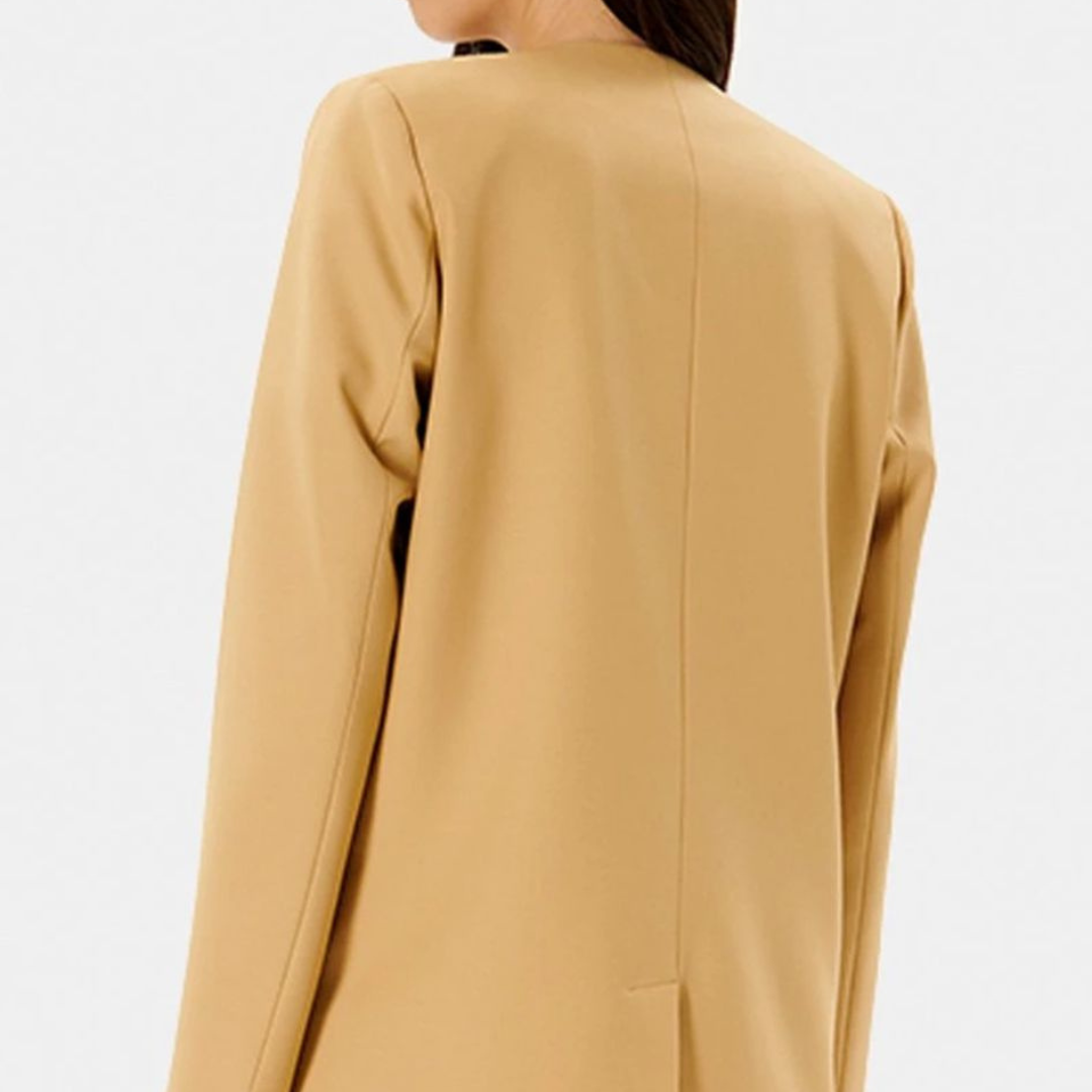 Blazer bege visto de costas com fundo neutro