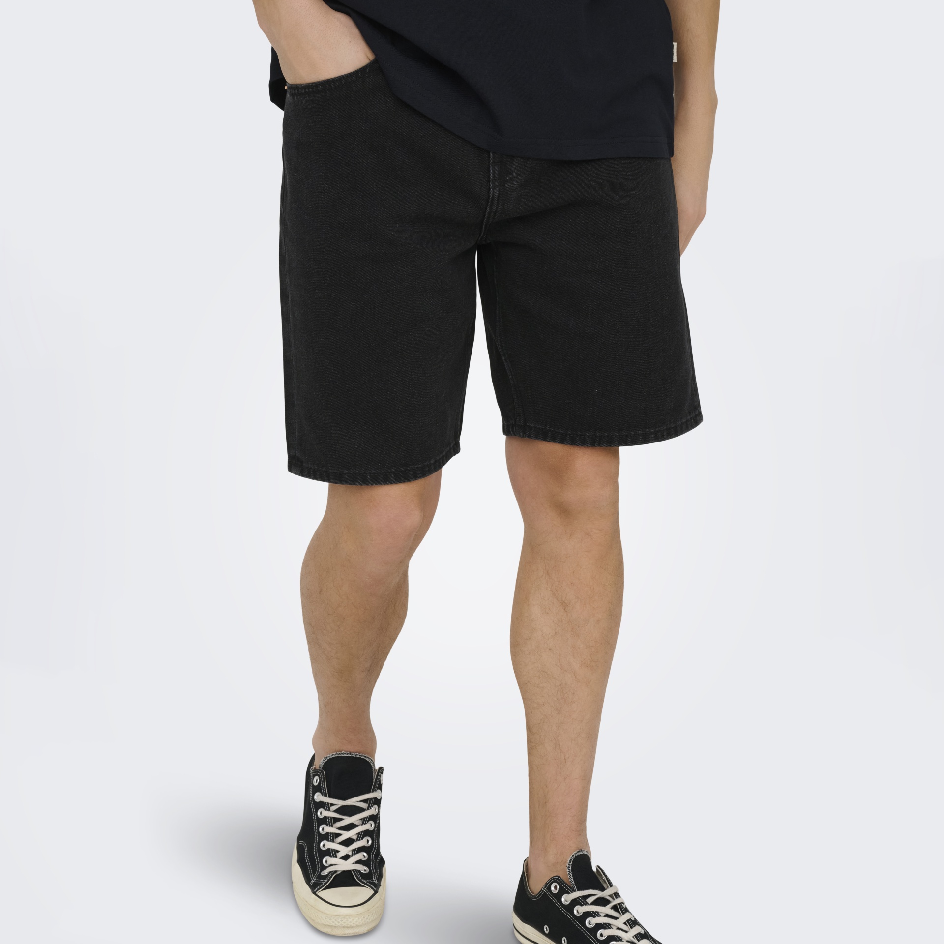 Calções de ganga pretos com t-shirt preta e ténis pretos