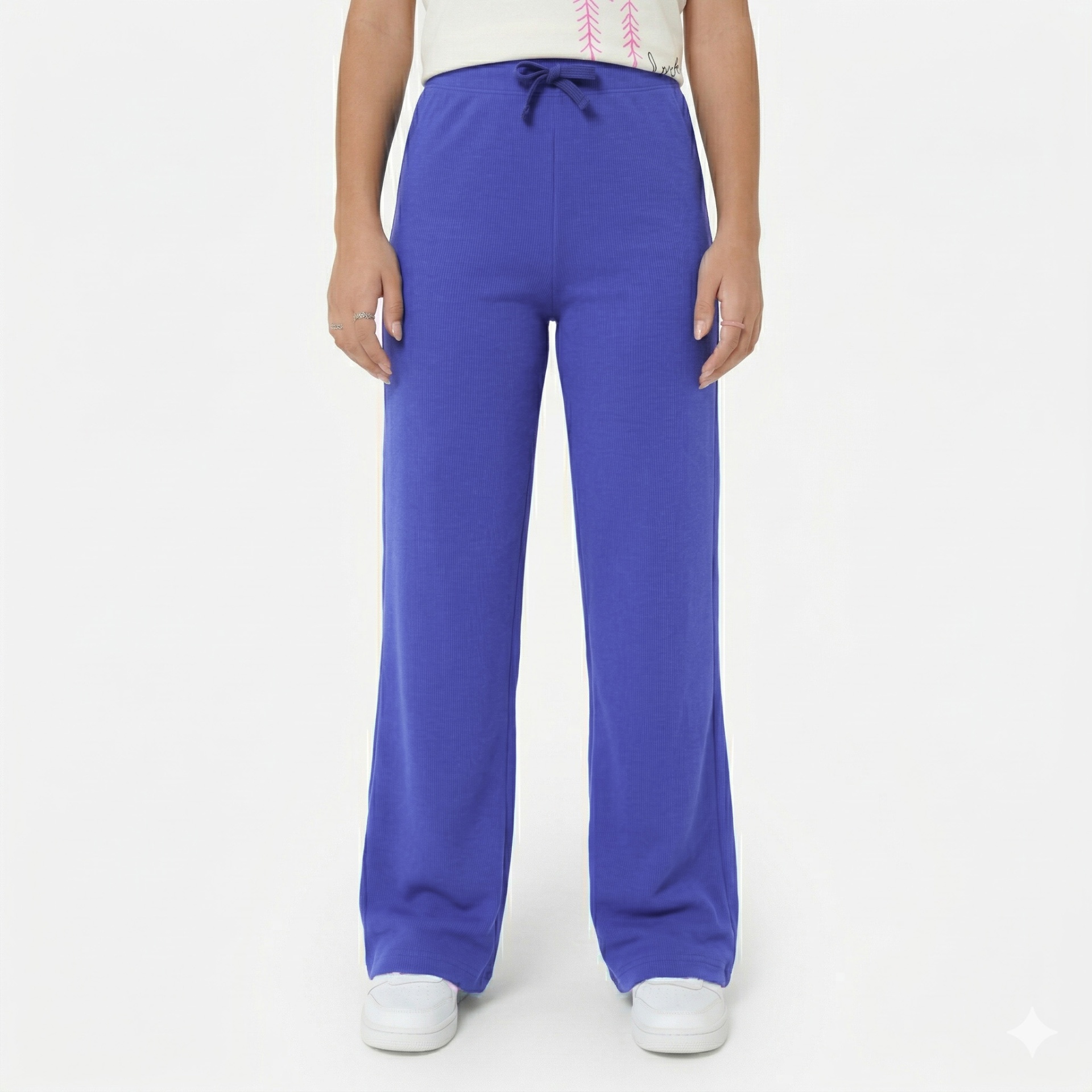 Calças largas azuis com cordão na cintura e sapatos brancos