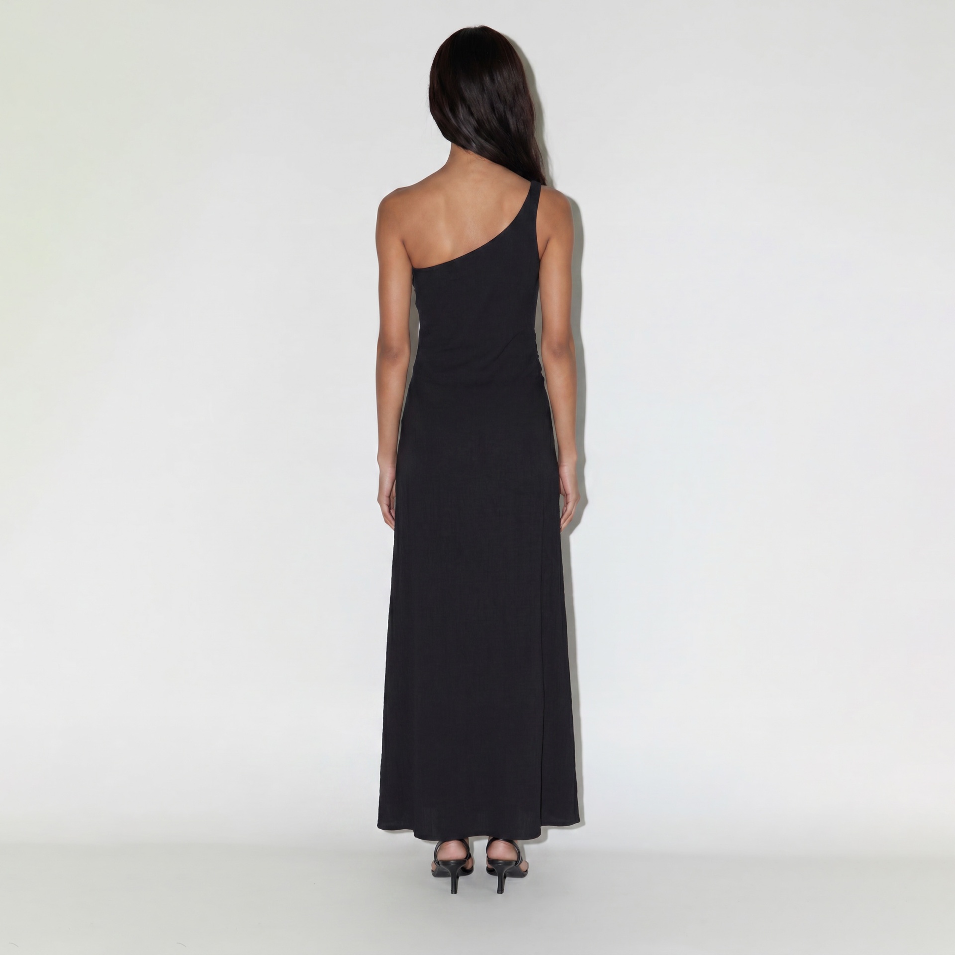 Vestido preto longo de um ombro só visto de costas