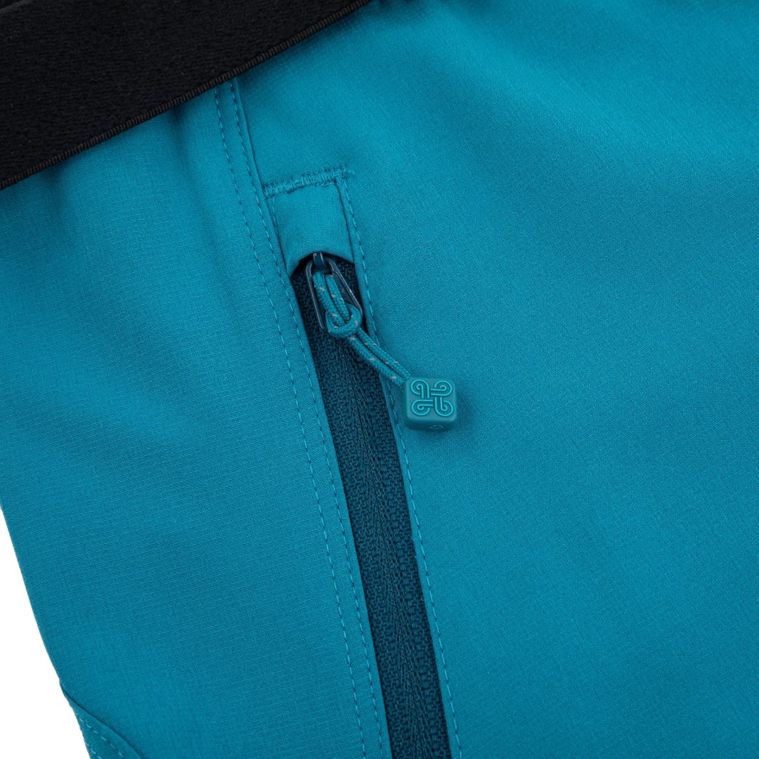 Fecho de correr azul em tecido de roupa com textura lisa e parte preta ao fundo