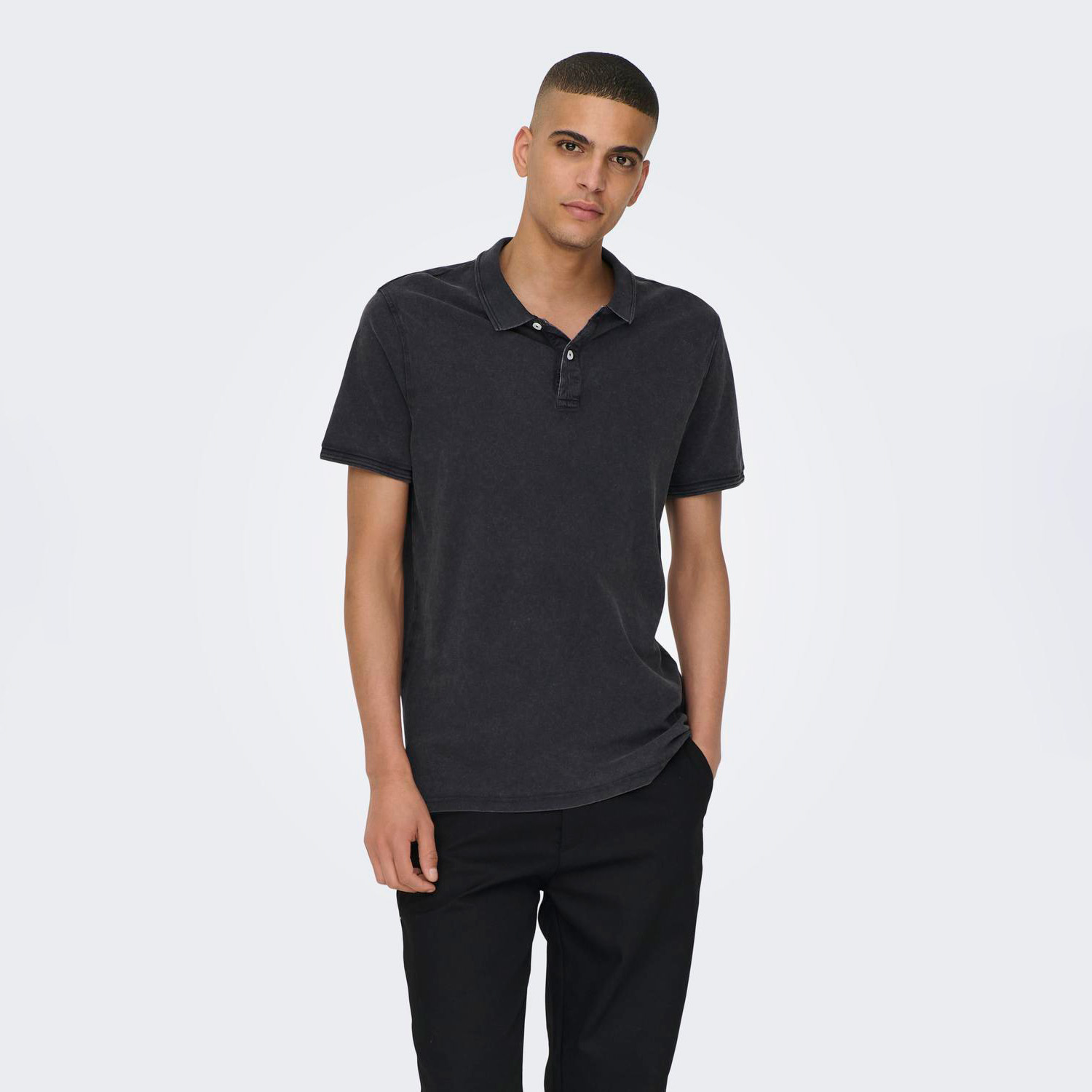 Homem com polo preta de algodão lavado e calças pretas