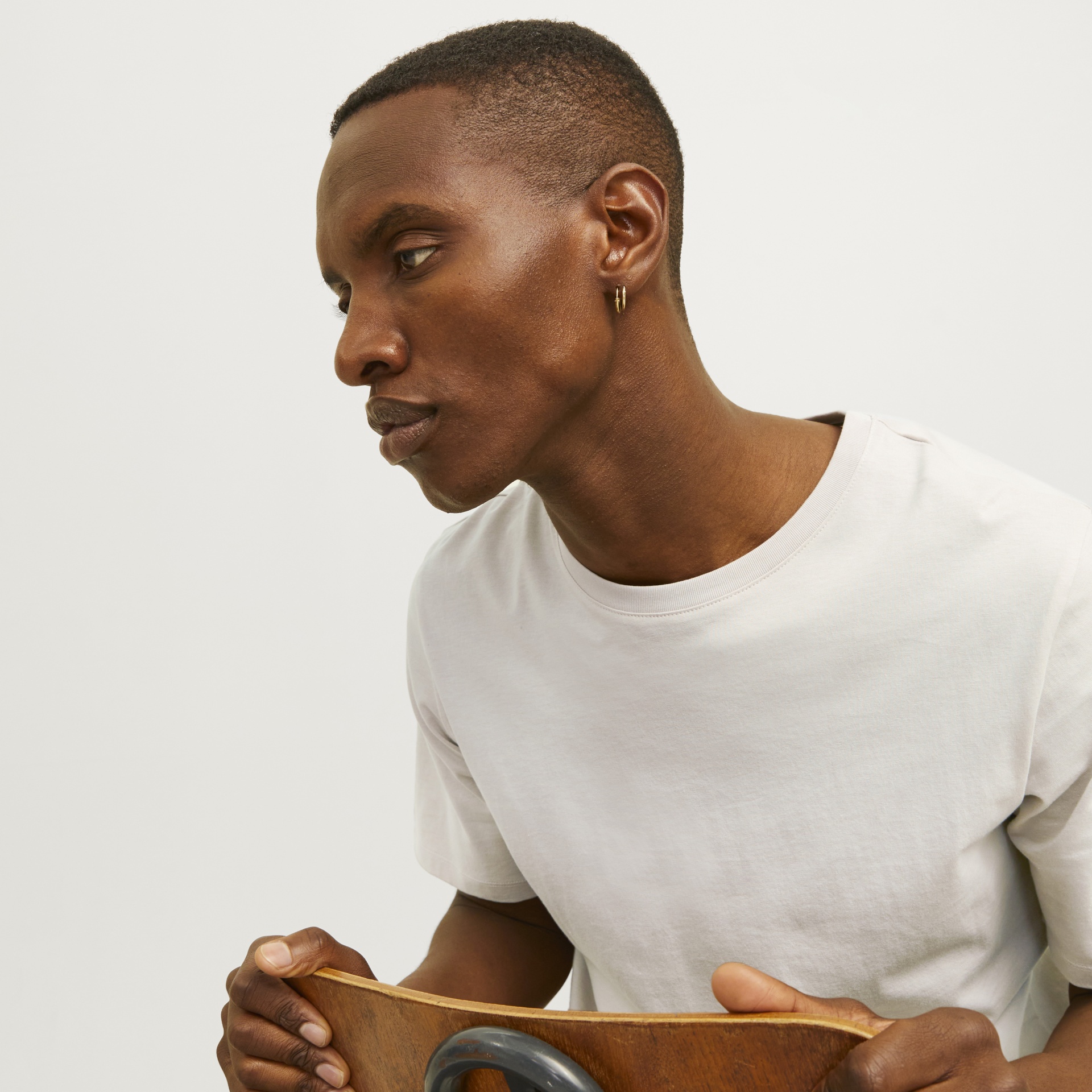 Homem de camisa branca segurando uma cadeira de madeira