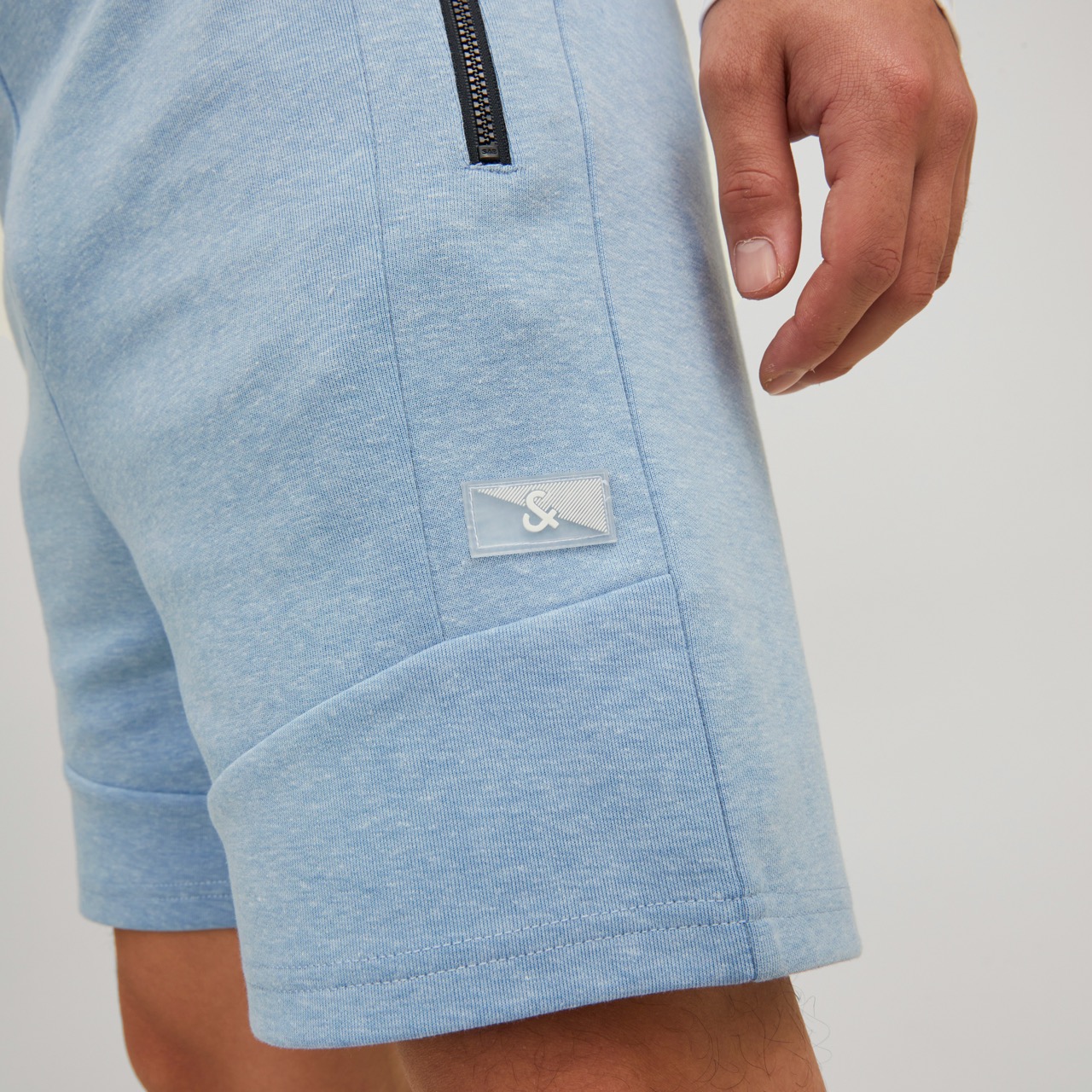 Calções de ganga azuis claros com bolso zip e etiqueta branca
