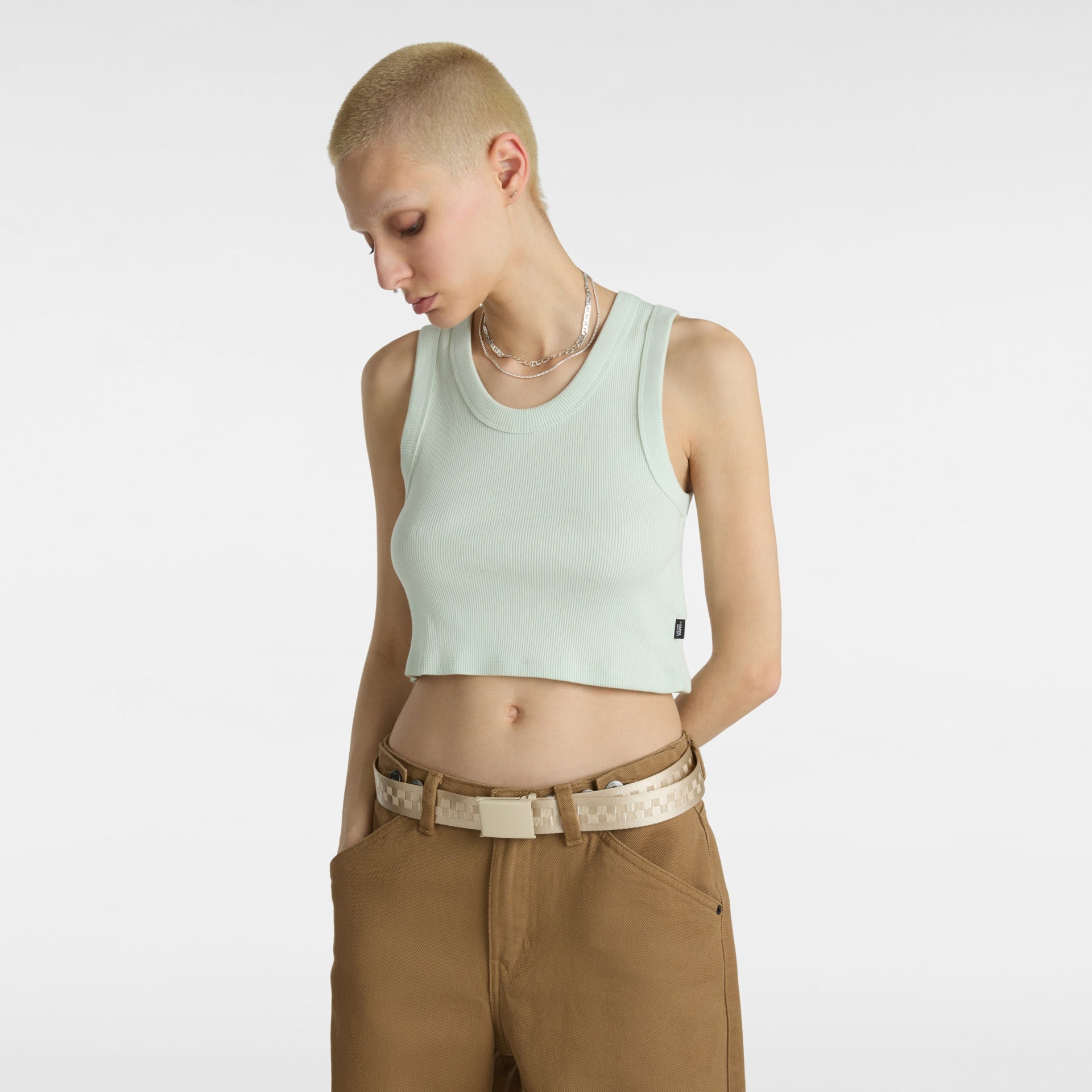 Top cropped verde claro de malha canelada com calças castanhas e cinto bege.