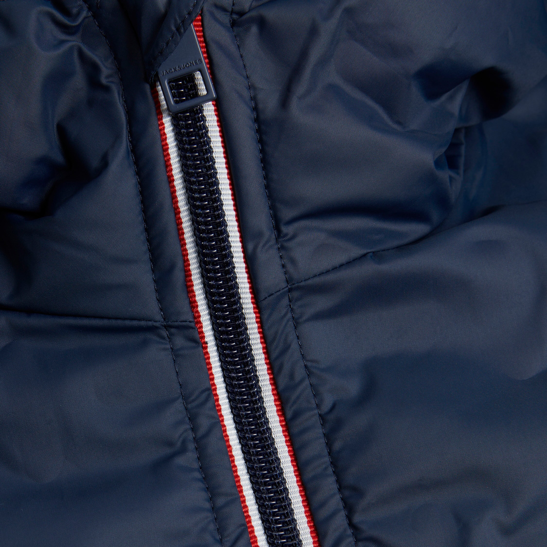 Casaco acolchoado azul escuro com fecho de correr central azul, branco e vermelho