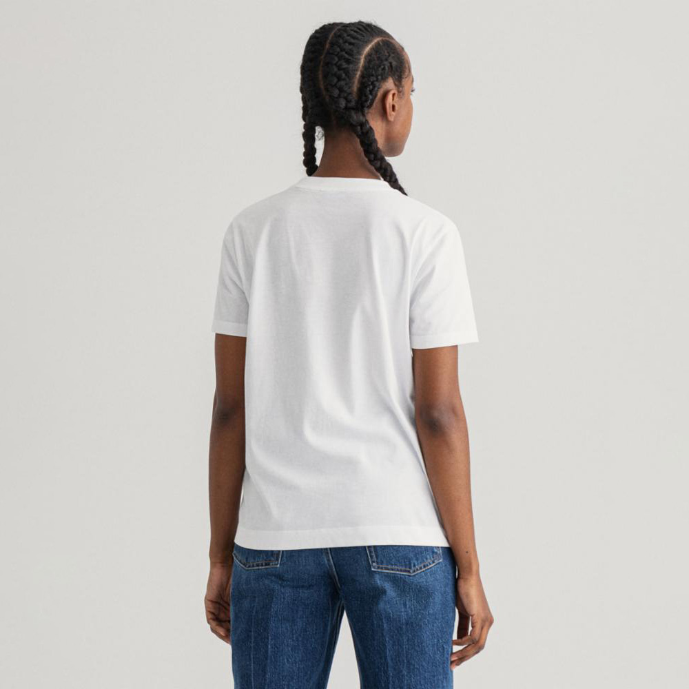 Pessoa de costas com t-shirt branca e calças de ganga azul em fundo cinzento