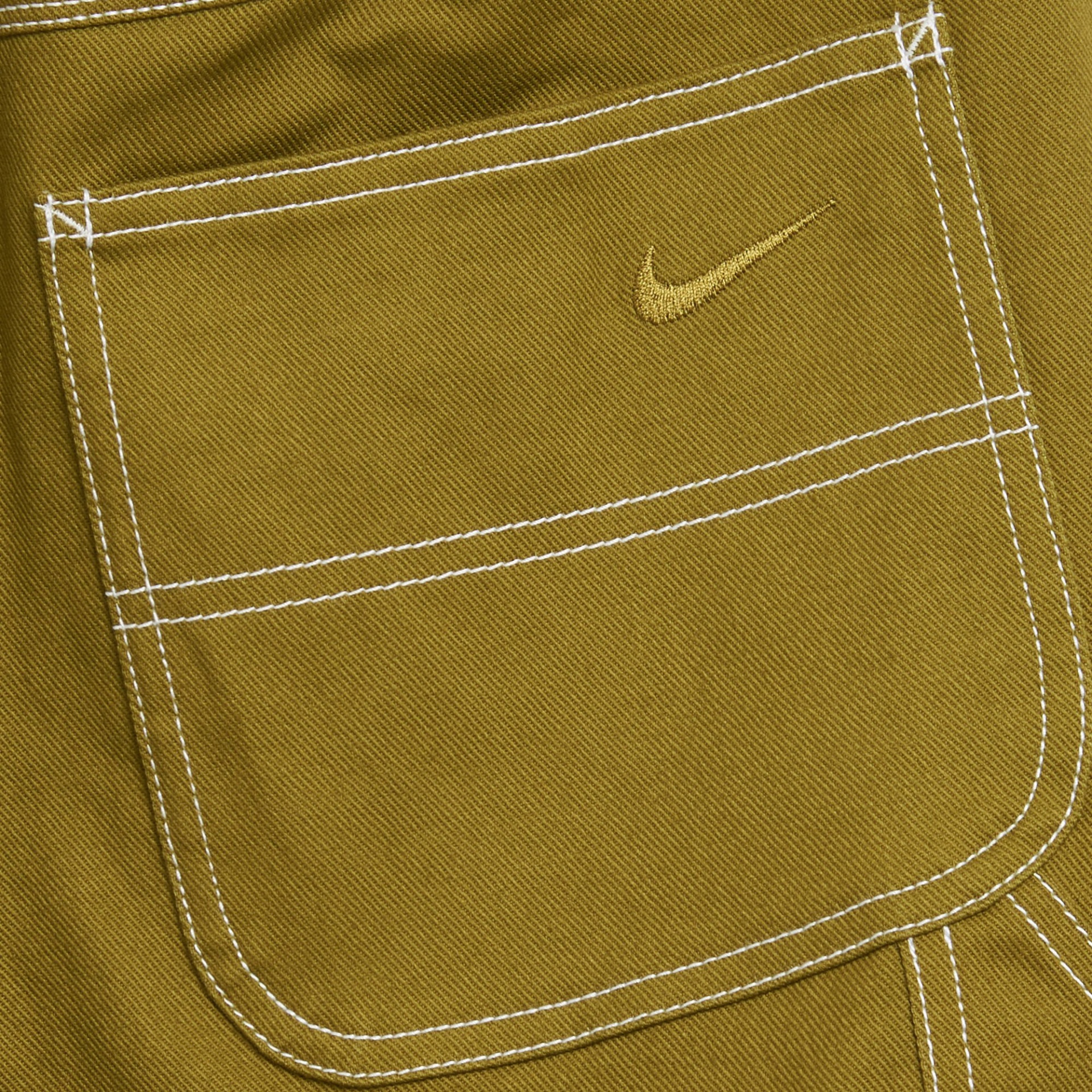 Bolso castanho-oliva com costuras brancas e logótipo Nike amarelo bordado.