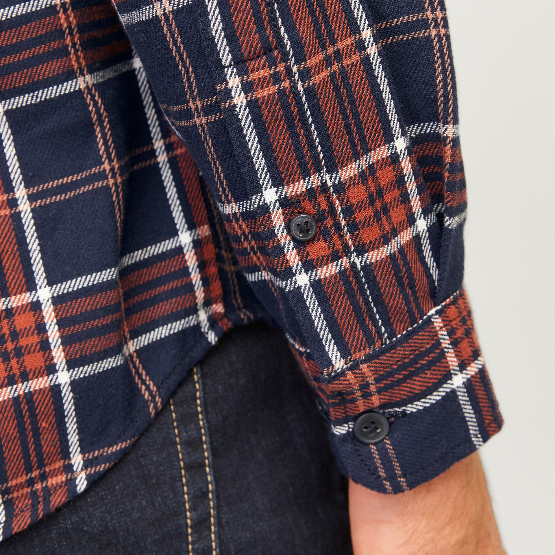 Manga de camisa xadrez azul, laranja e branco com botões pretos