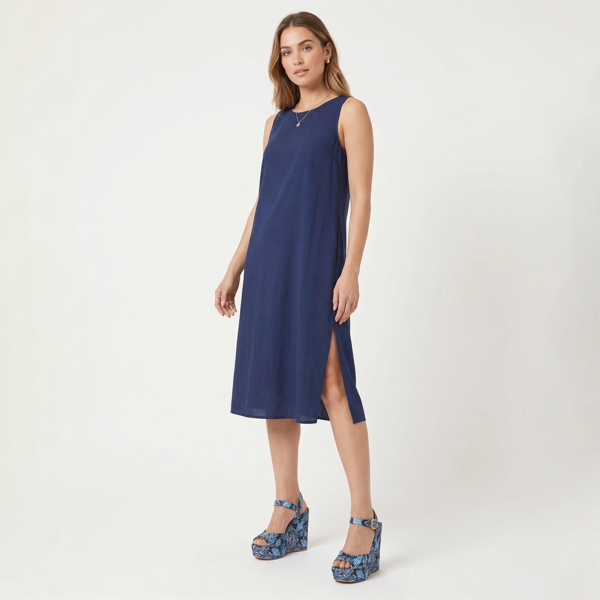 Vestido midi azul escuro com fenda lateral e sandálias de cunha com padrão de folhas