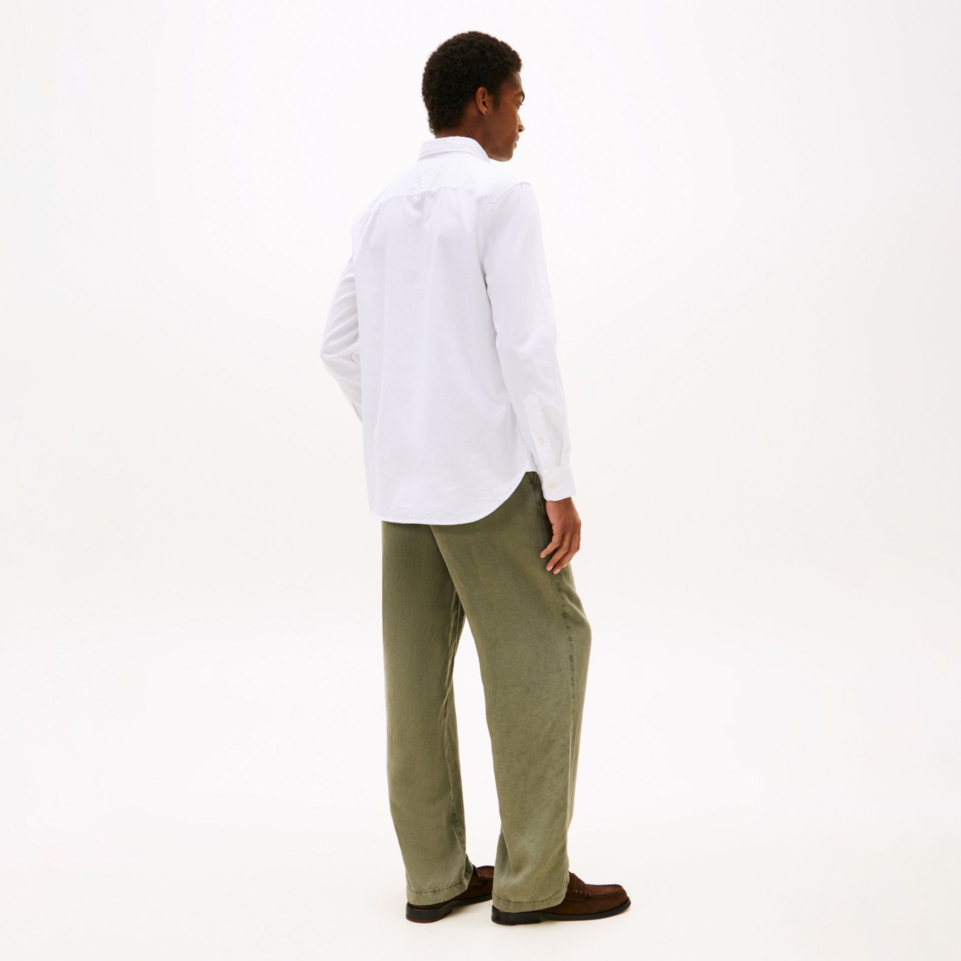 Pessoa de costas com camisa branca e calças verde-oliva