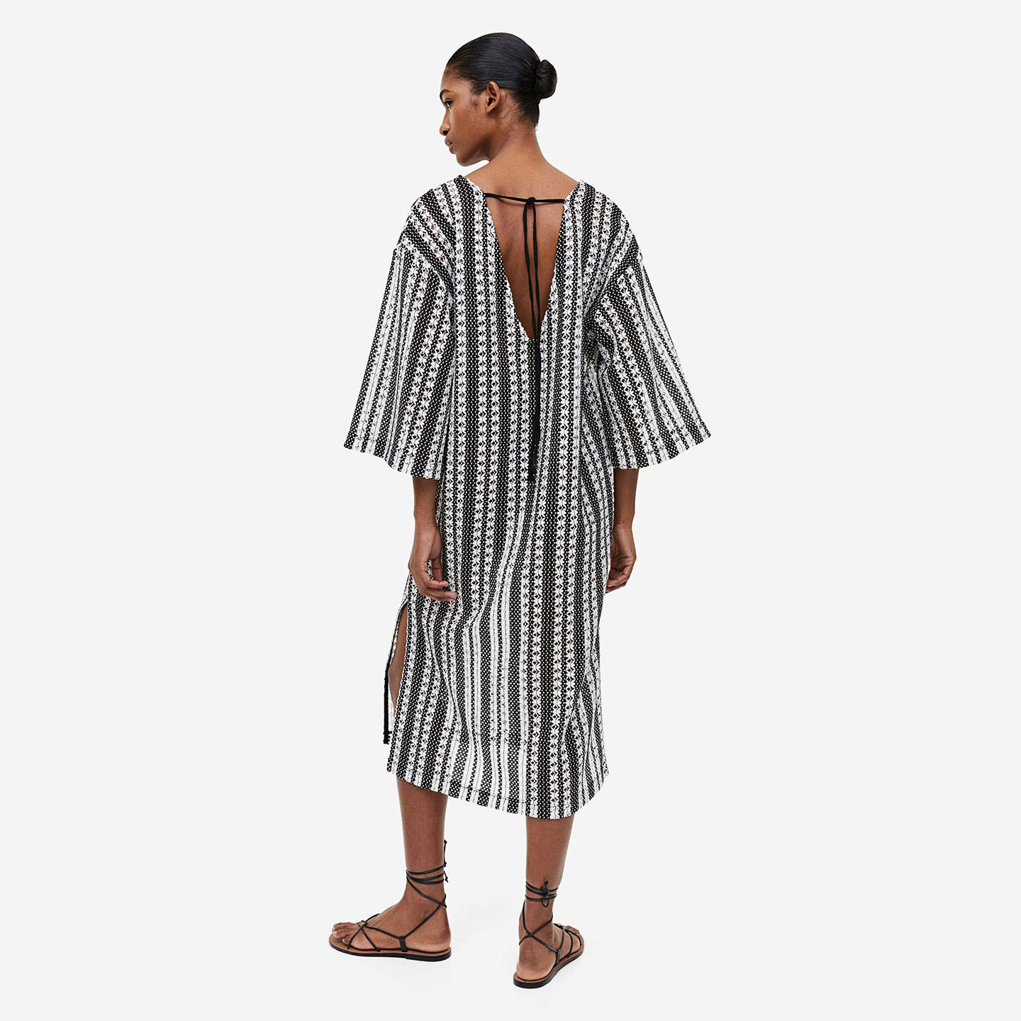Vestido midi preto e branco com padrão geométrico e manga larga, visto de costas