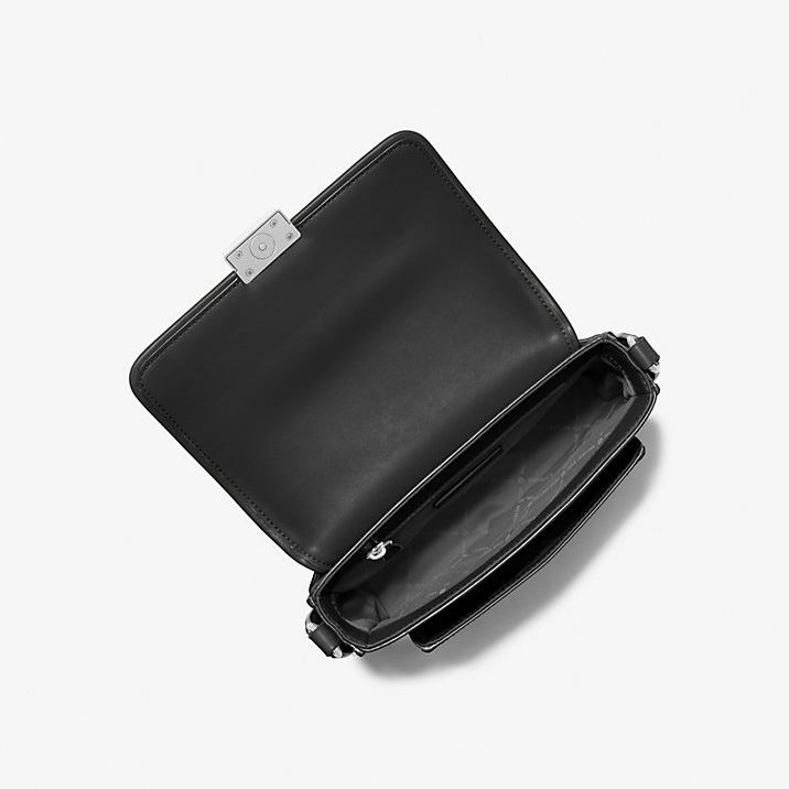 Mala preta de pele sintética aberta com fecho metálico