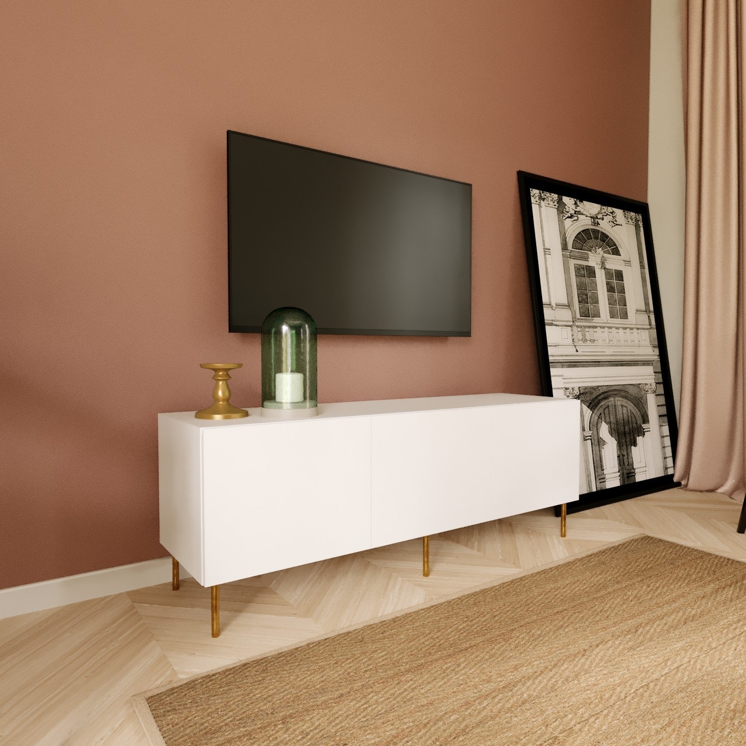 Móvel branco com pernas douradas, castiçal, lanterna com vela, TV preta montada na parede rosa, quadro a preto e branco encostado.