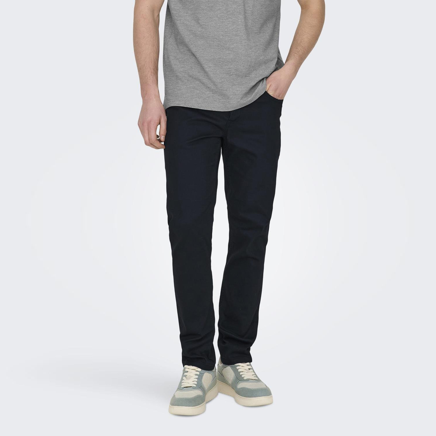 Calças slim escuras com t-shirt cinzenta e sapatilhas claras
