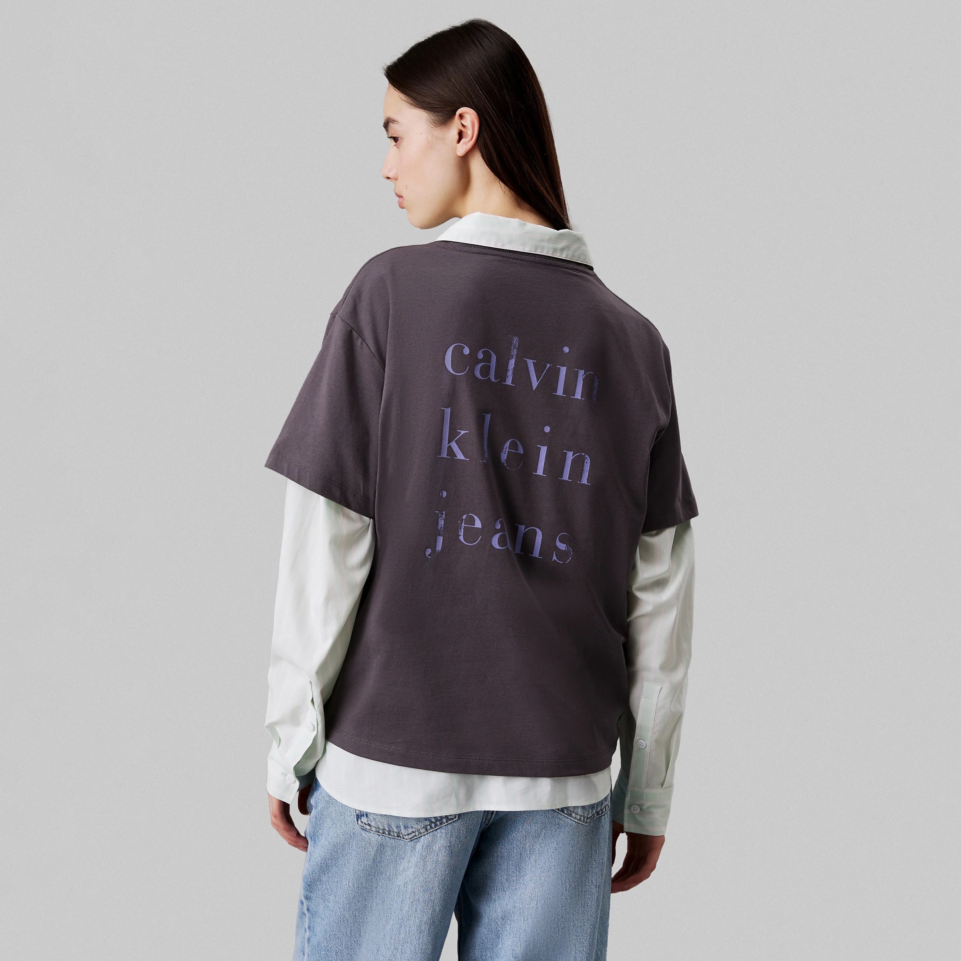 Vista de trás de t-shirt cinzenta escura com logo lilás calvin klein jeans