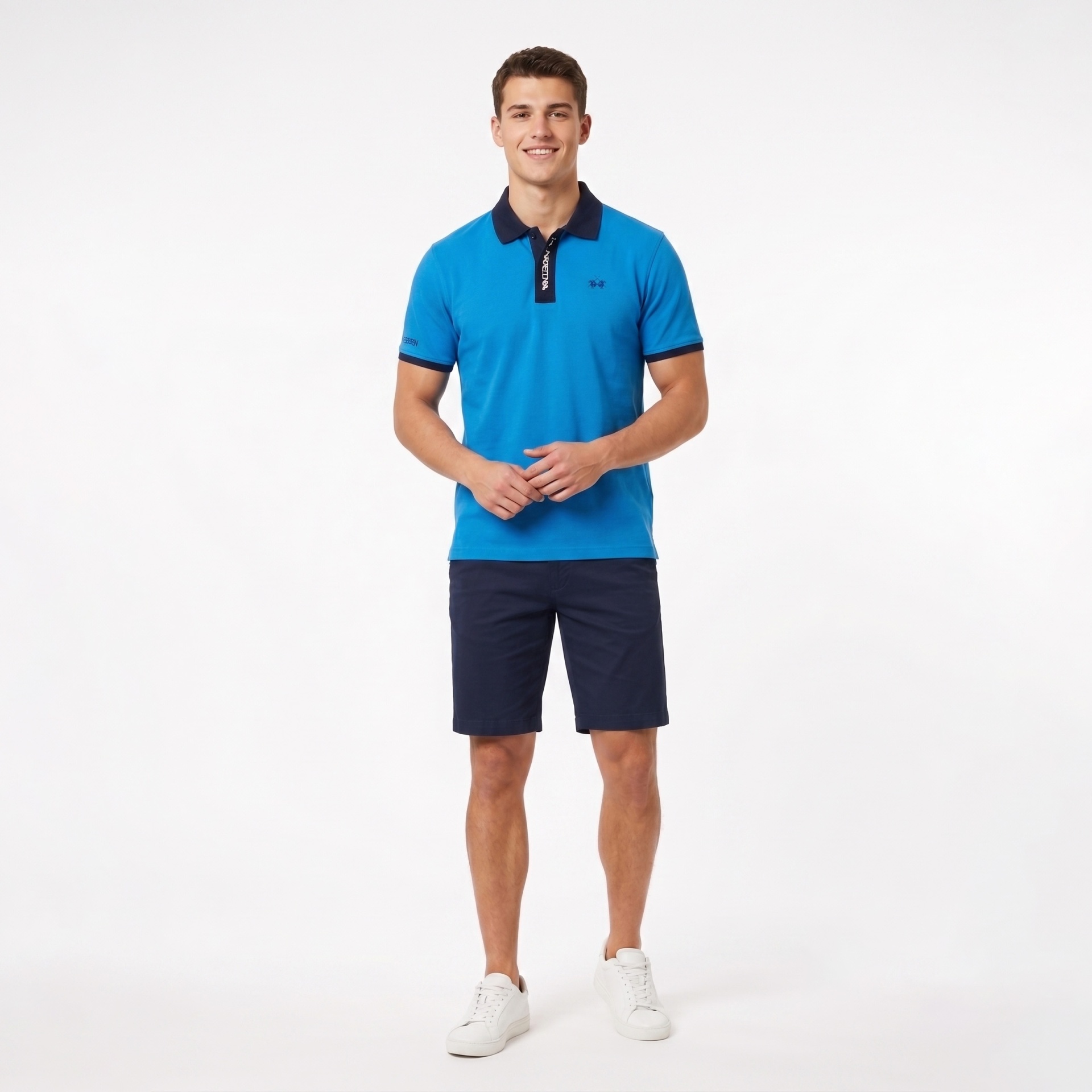 Homem com polo azul e bermuda azul escura em fundo branco