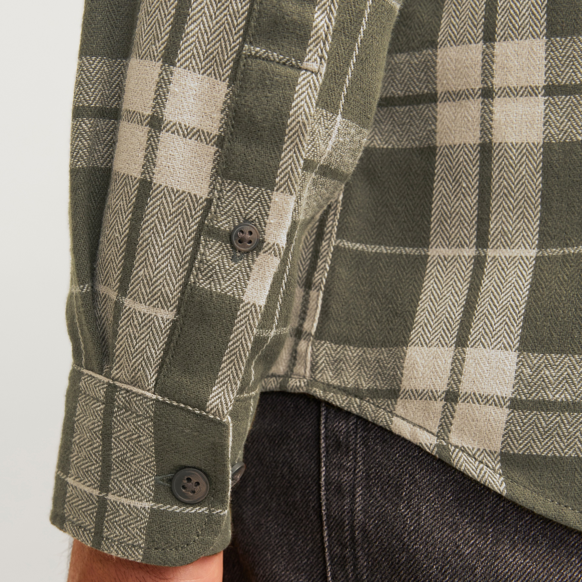 Manga de camisa xadrez verde e bege com botão castanho