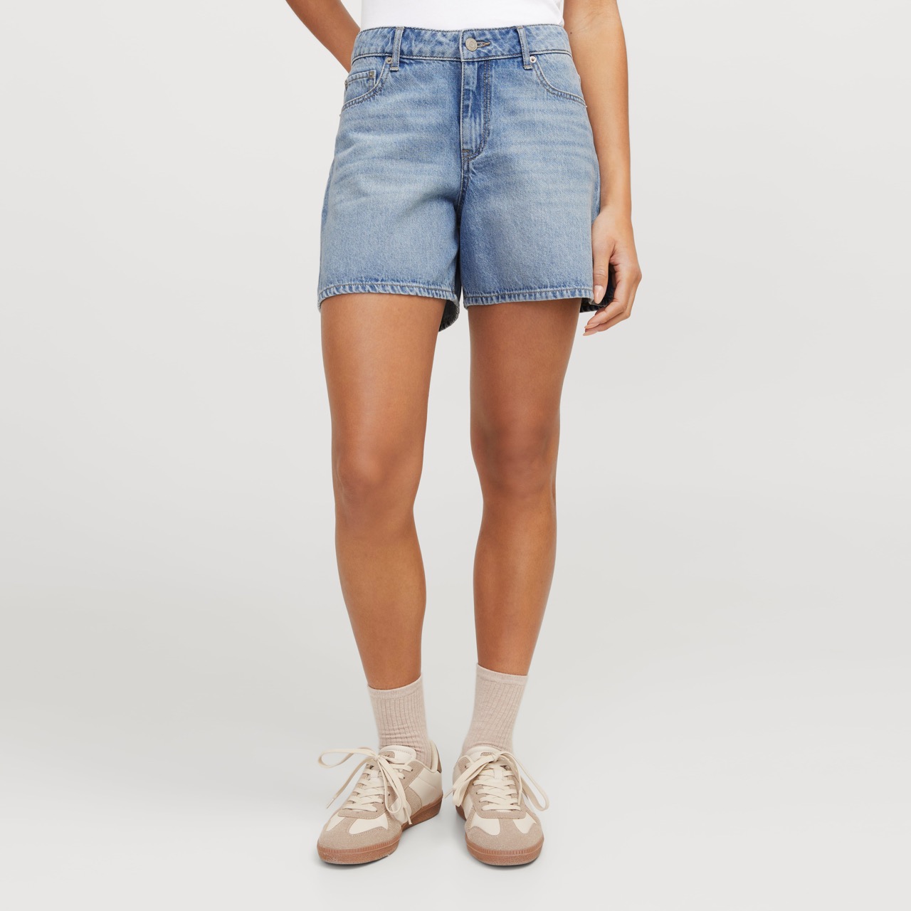 Calções de ganga azuis de corte reto usados com ténis bege