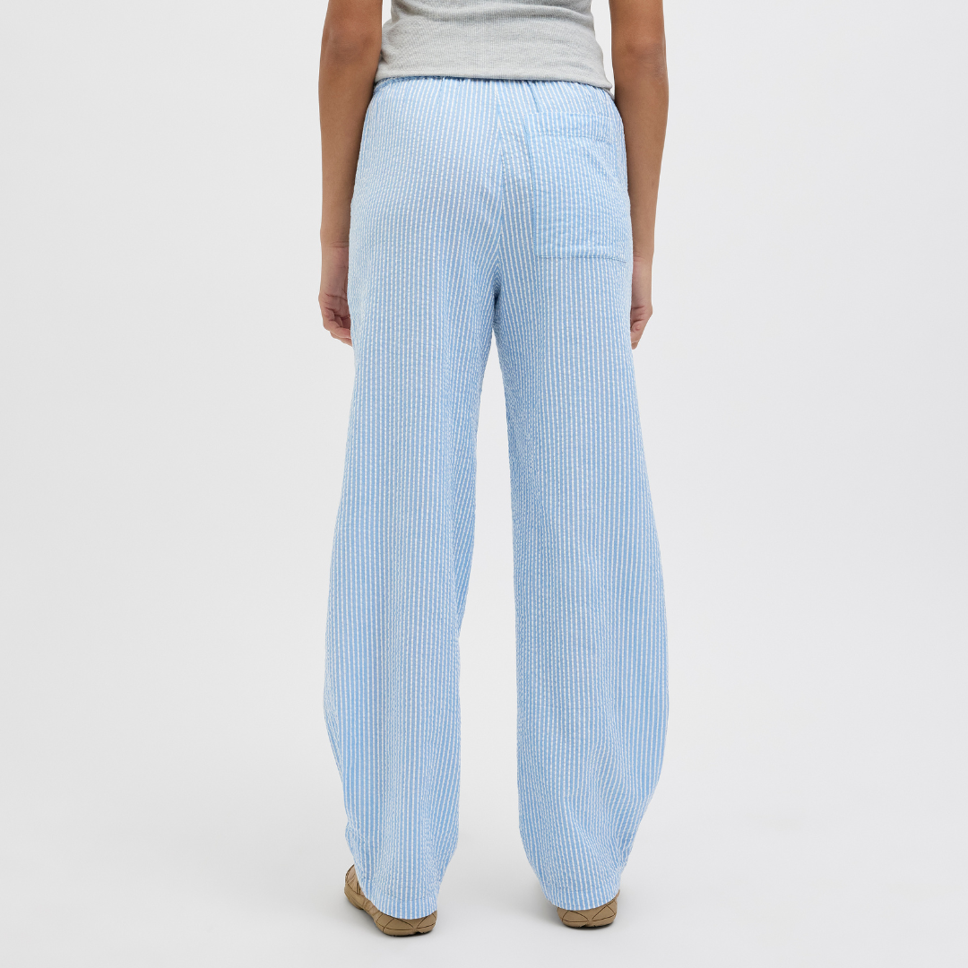 Calças azuis com riscas brancas, texturizadas, com bolso traseiro, vistas de costas