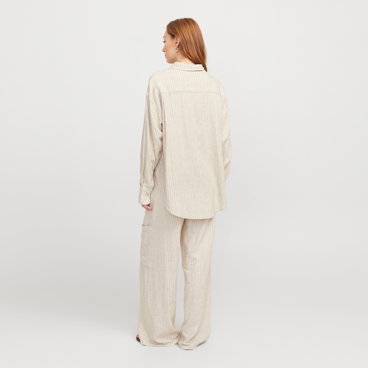 Conjunto de roupa listrada bege claro visto de costas