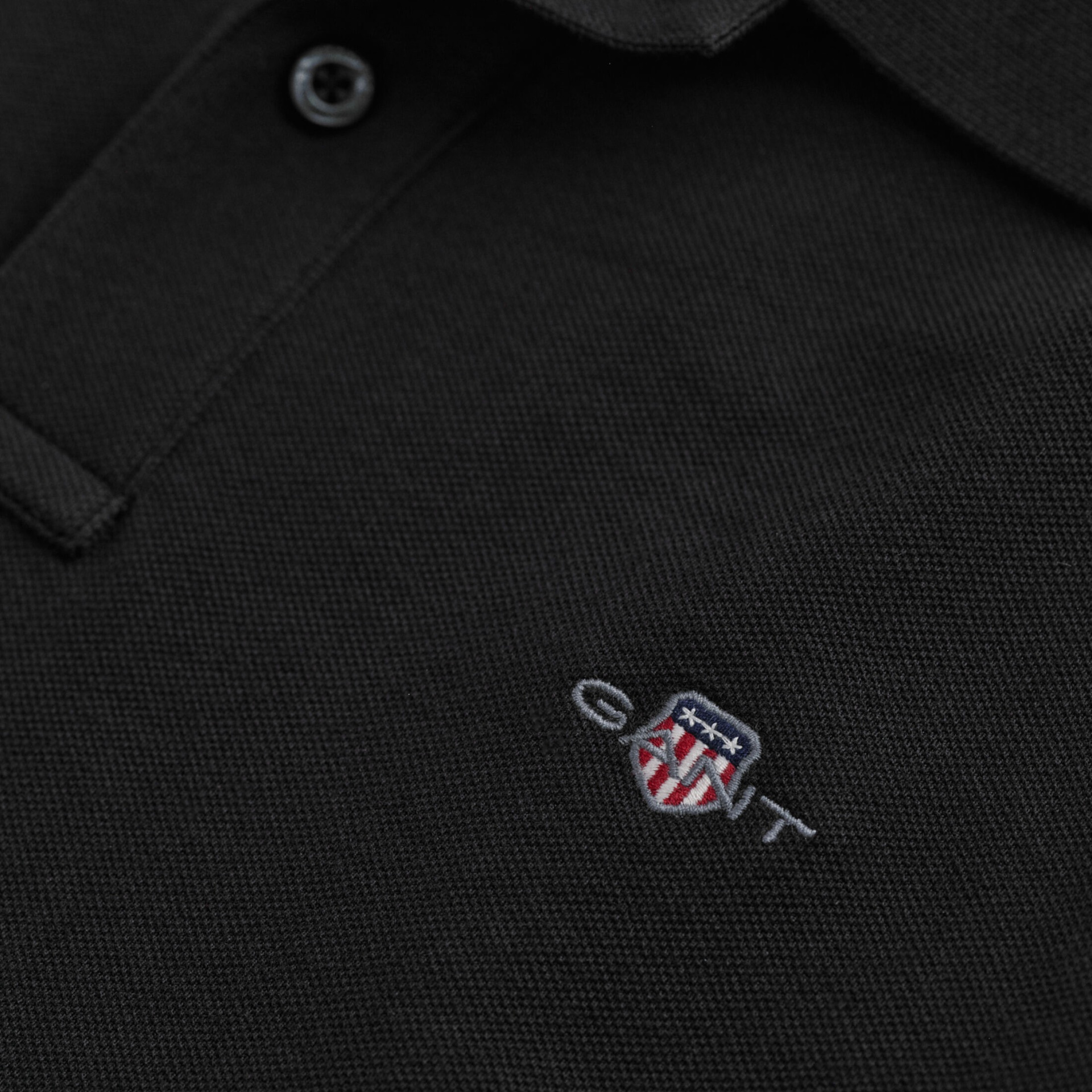 Polo preto com bordado colorido no peito