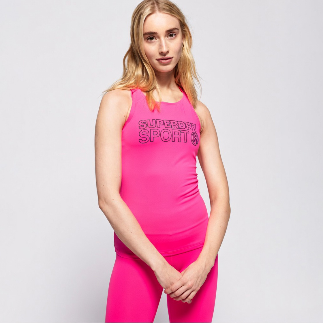 Top desportivo rosa com texto preto e leggings da mesma cor