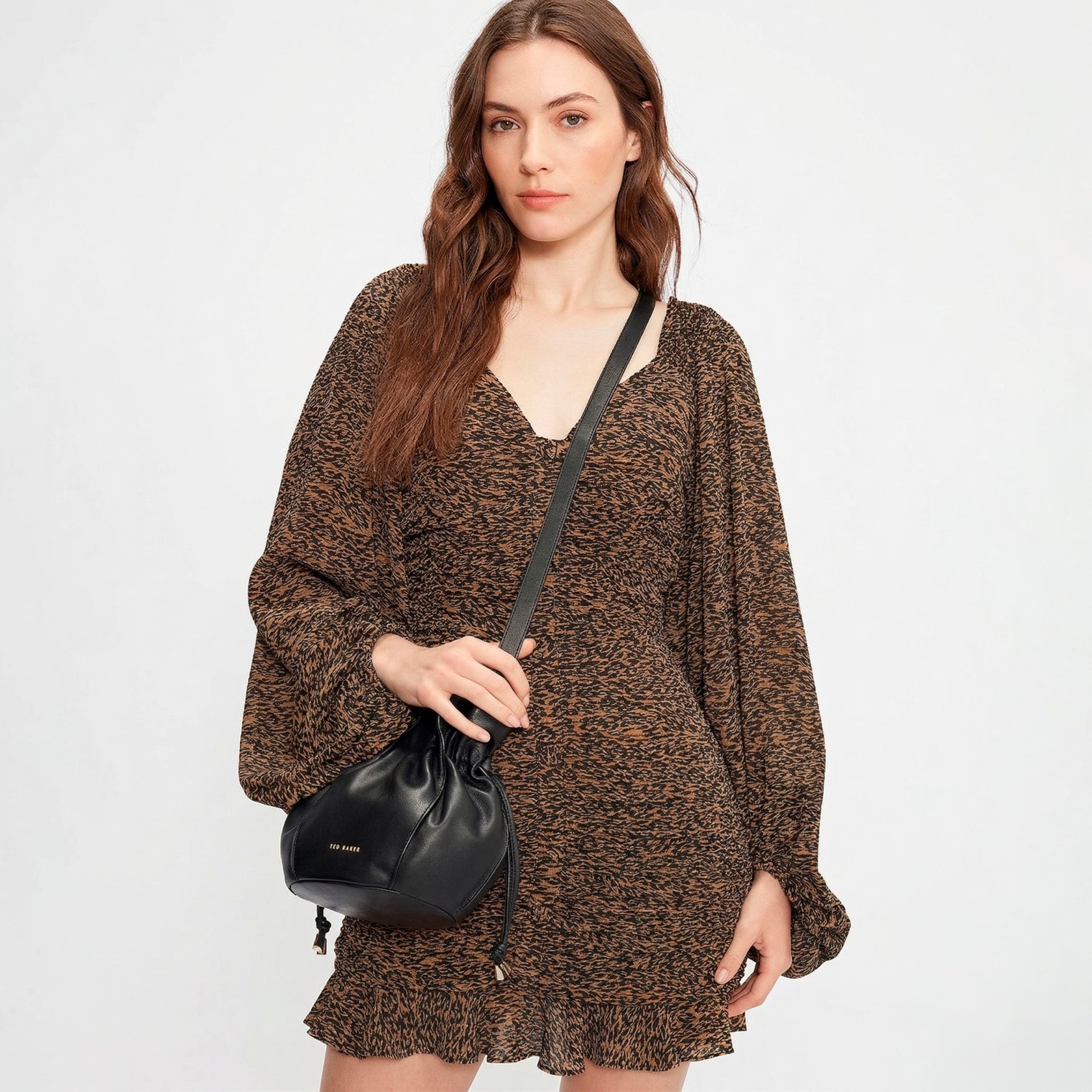 Vestido curto castanho e preto com saco tiracolo preto de couro.