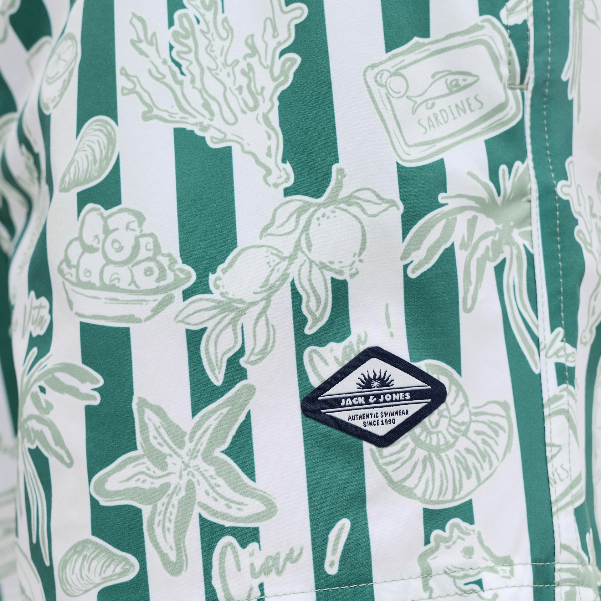 Estampado com motivos marinhos em pano com riscas verdes e brancas