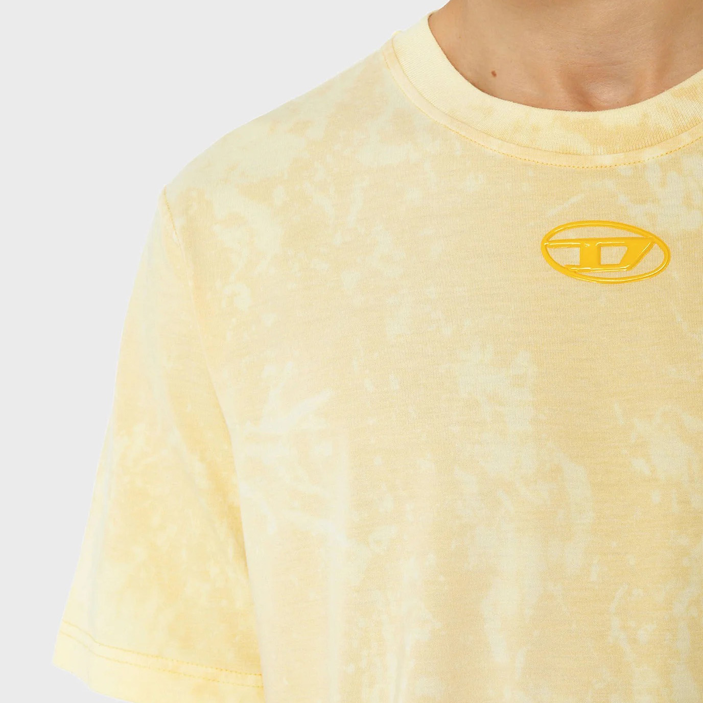 Camiseta amarelo claro com padrão tie-dye e estampagem amarela no peito