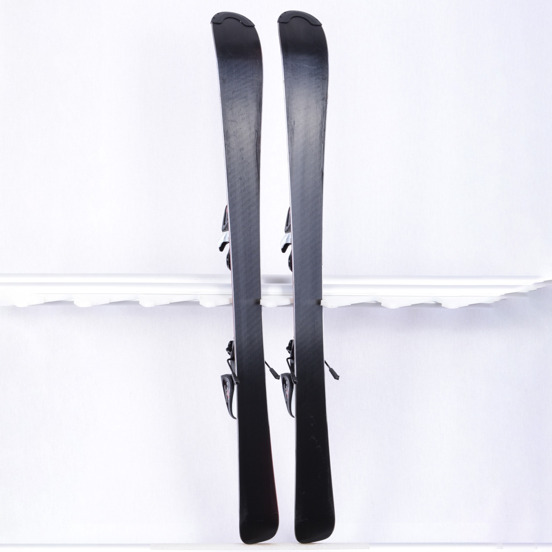 Par de esquis pretos com fixações em fundo branco