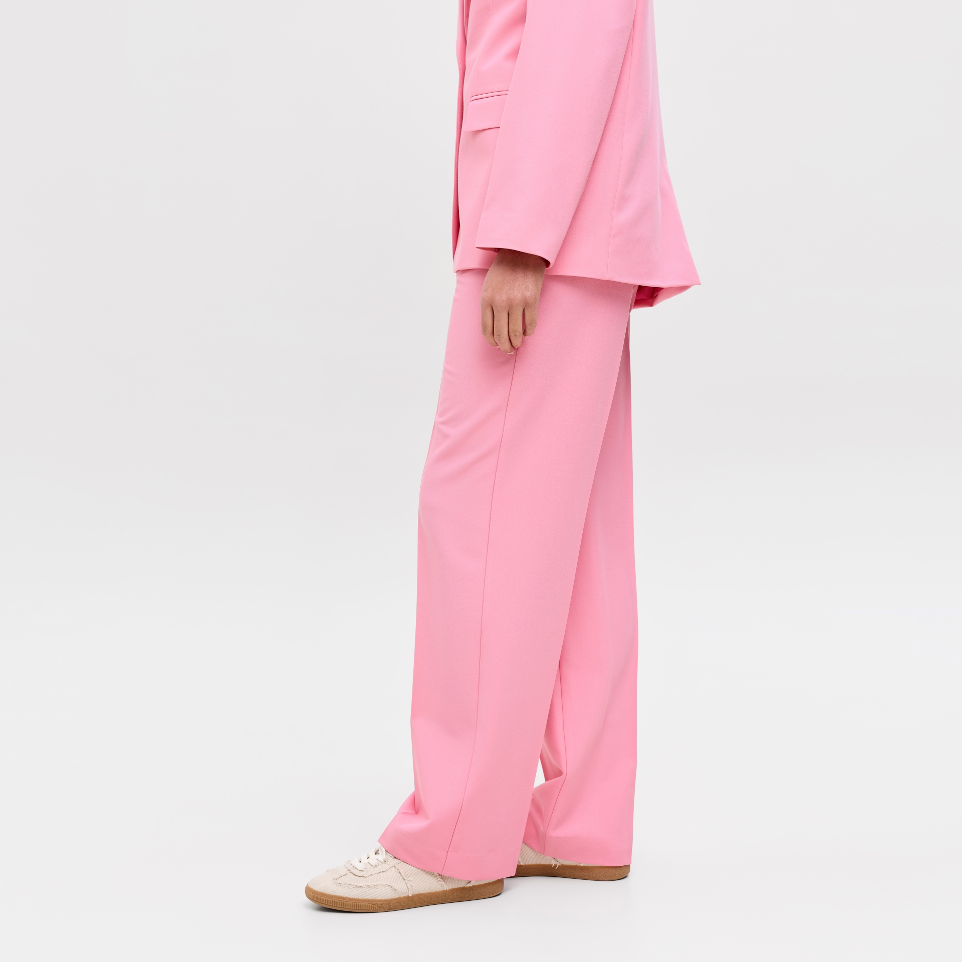 Calças largas rosa com sapatos desportivos bege