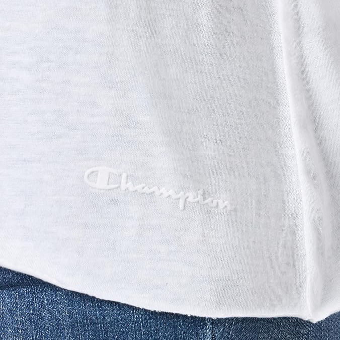Camiseta branca com logo Champion em relevo branco junto a calças de ganga azul.