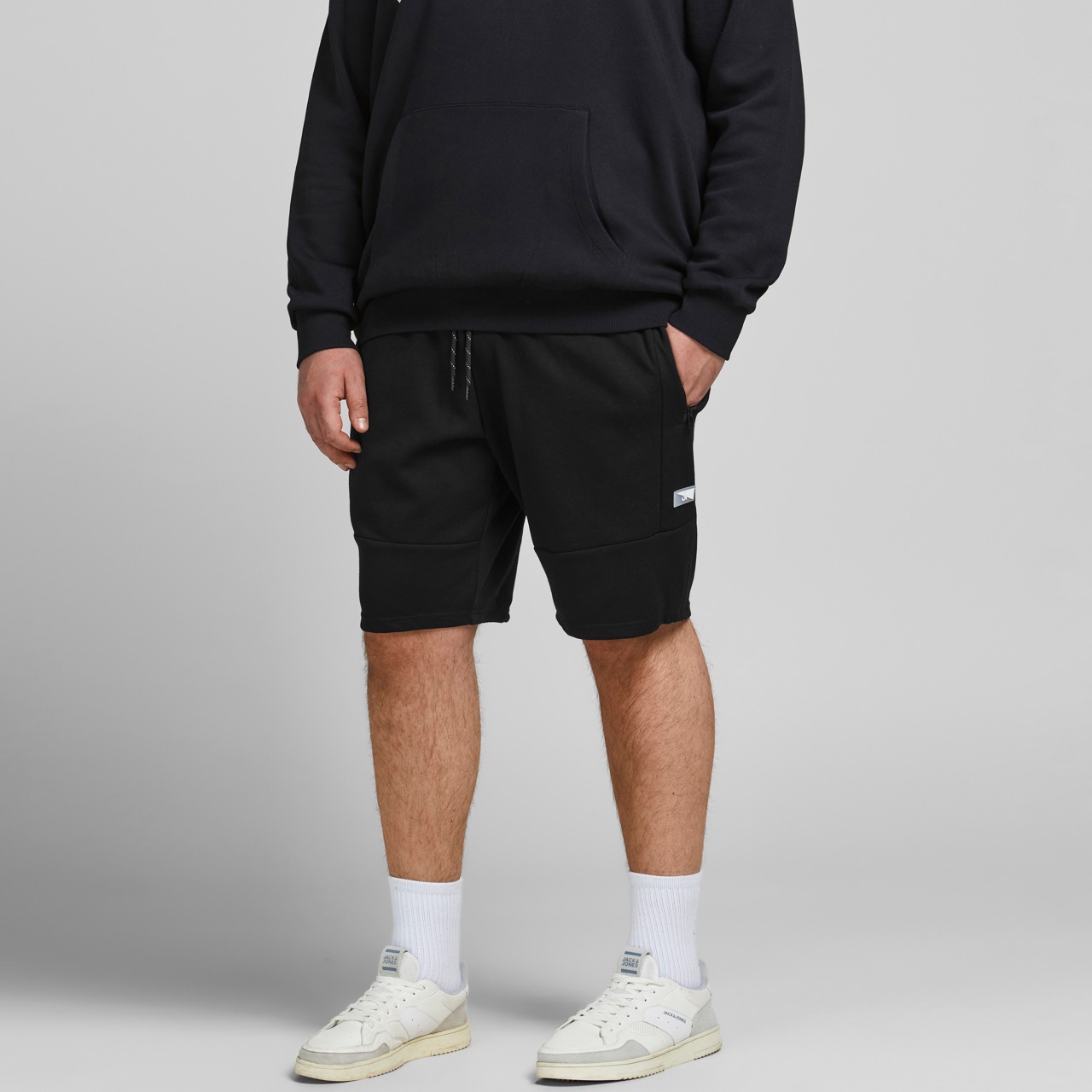 Calções pretos de algodão com etiqueta branca usados por homem