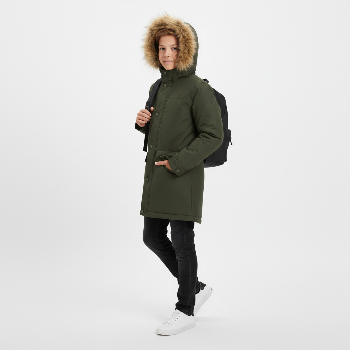 Casaco verde com capuz de pelo, calças pretas, ténis brancos e mochila preta