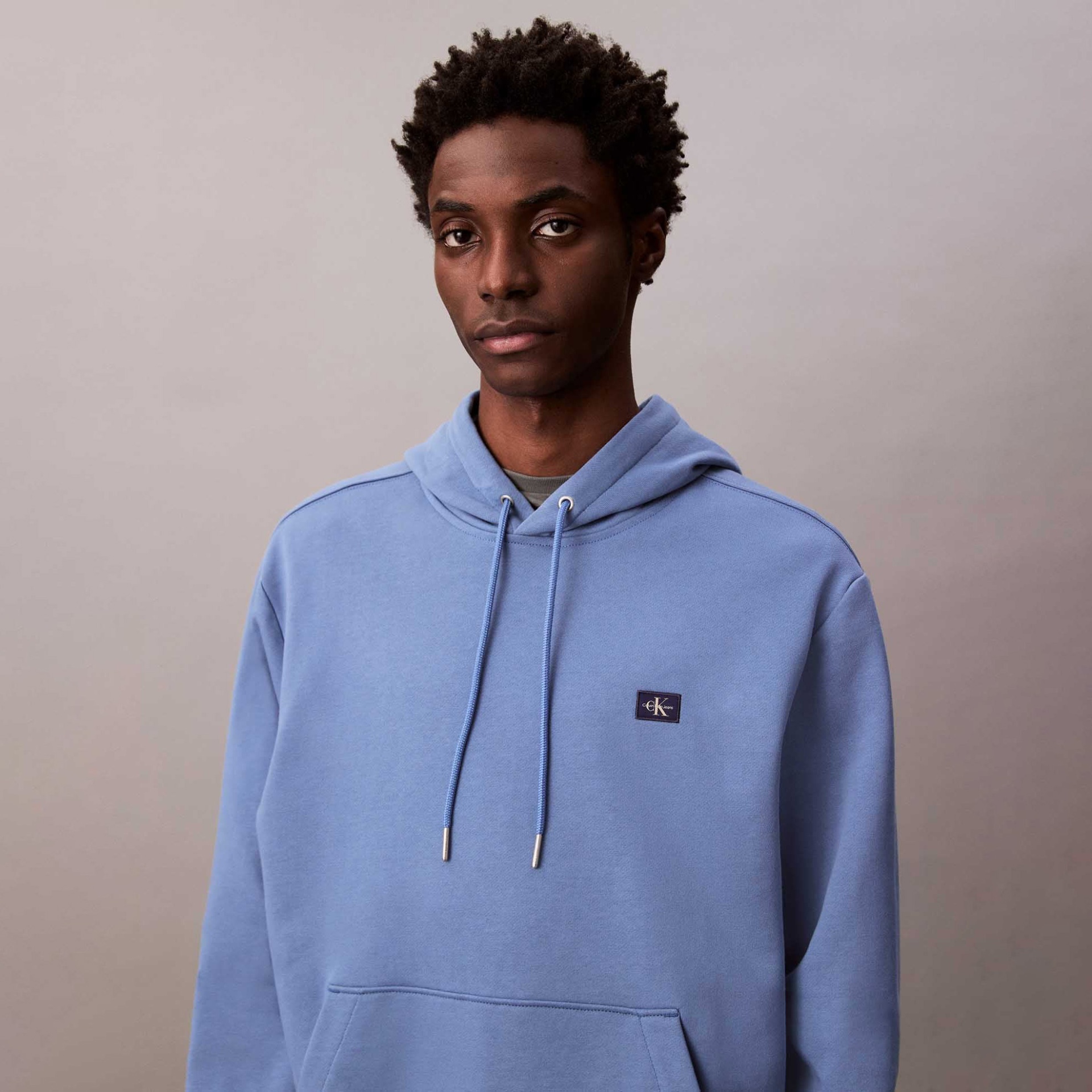 Sweatshirt azul claro com capuz e bolso canguru, com logótipo Calvin Klein no peito