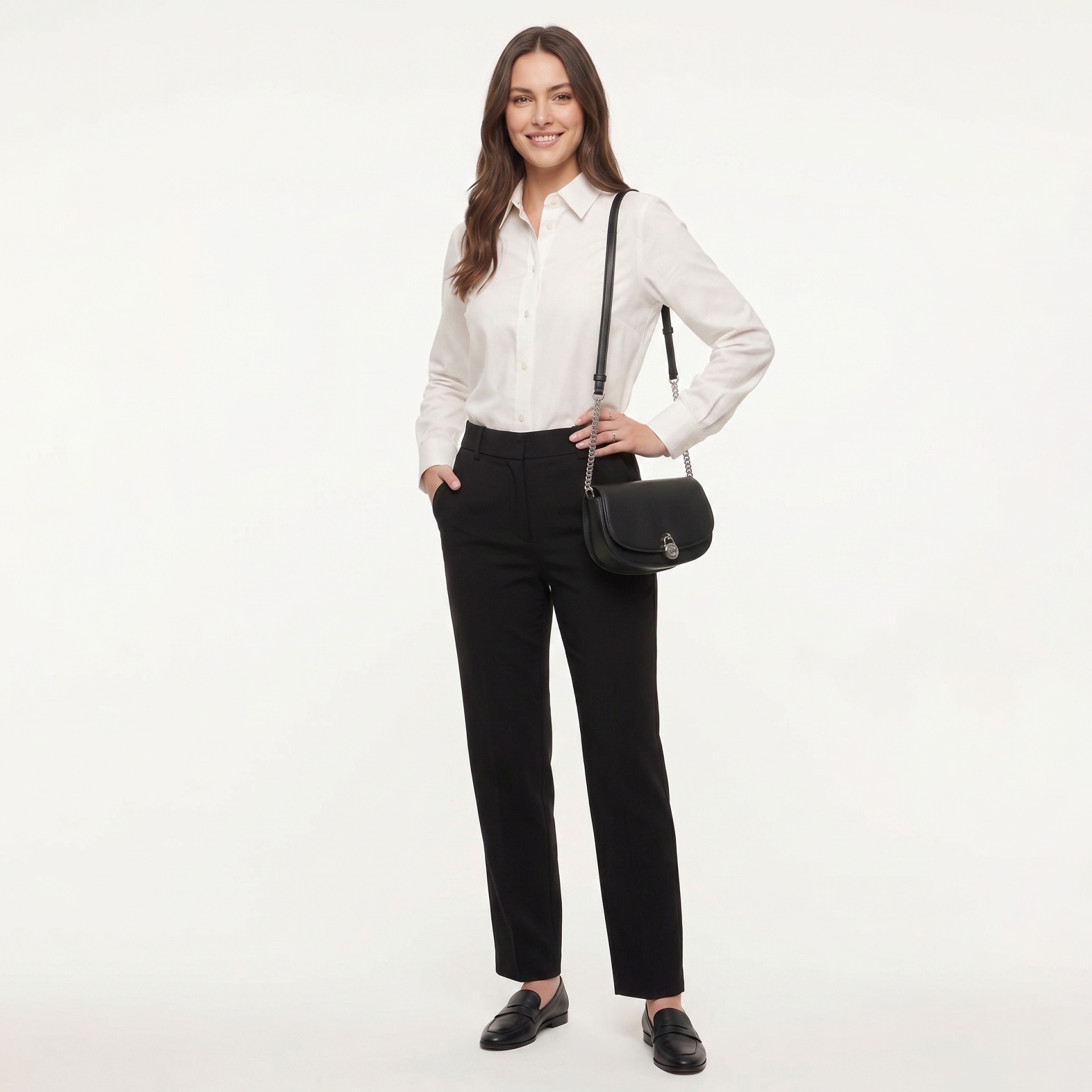 Mulher com camisa branca, calças pretas, sapatos pretos e mala preta com alça e corrente prateada.