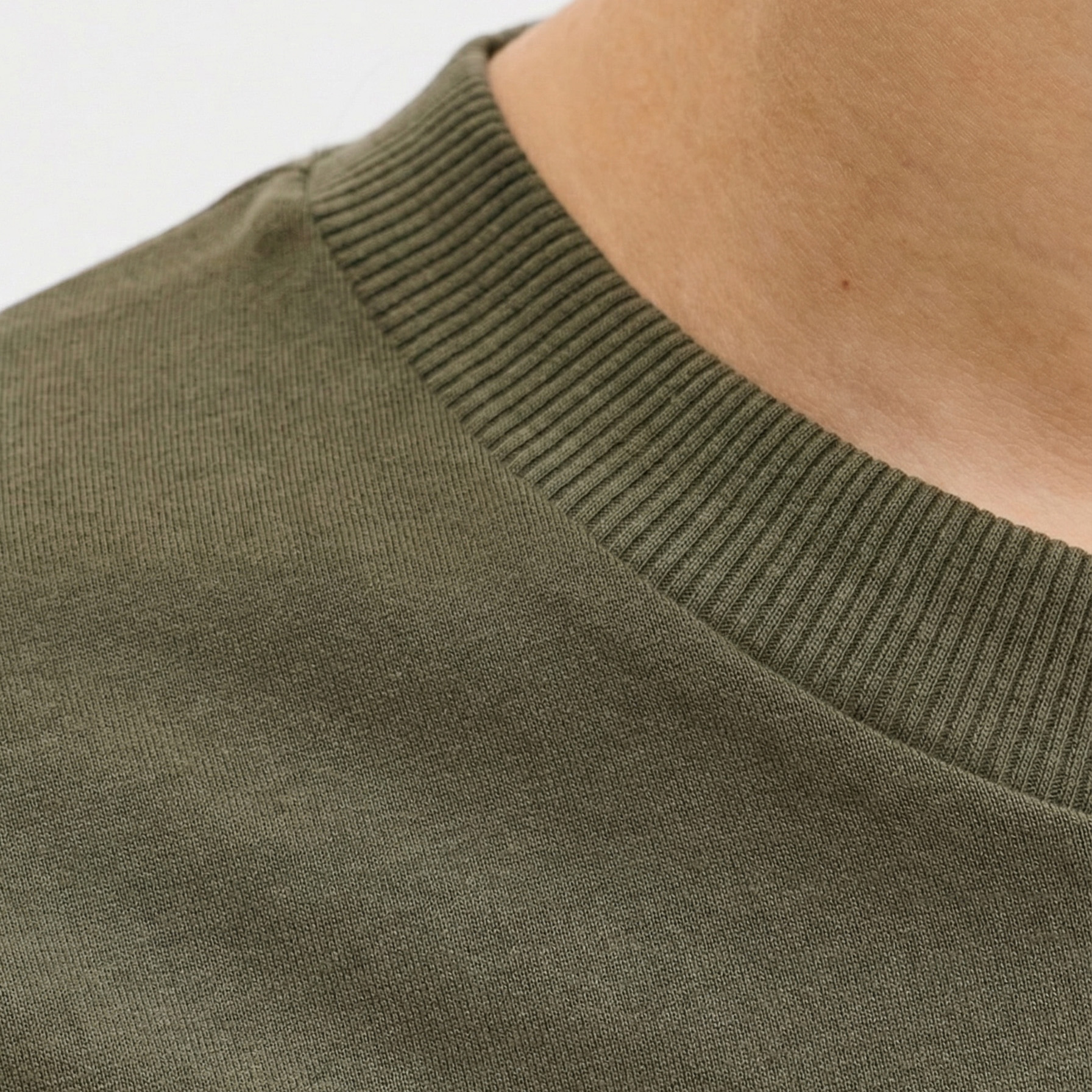 Close-up de vestido verde-oliva com decote redondo canelado.