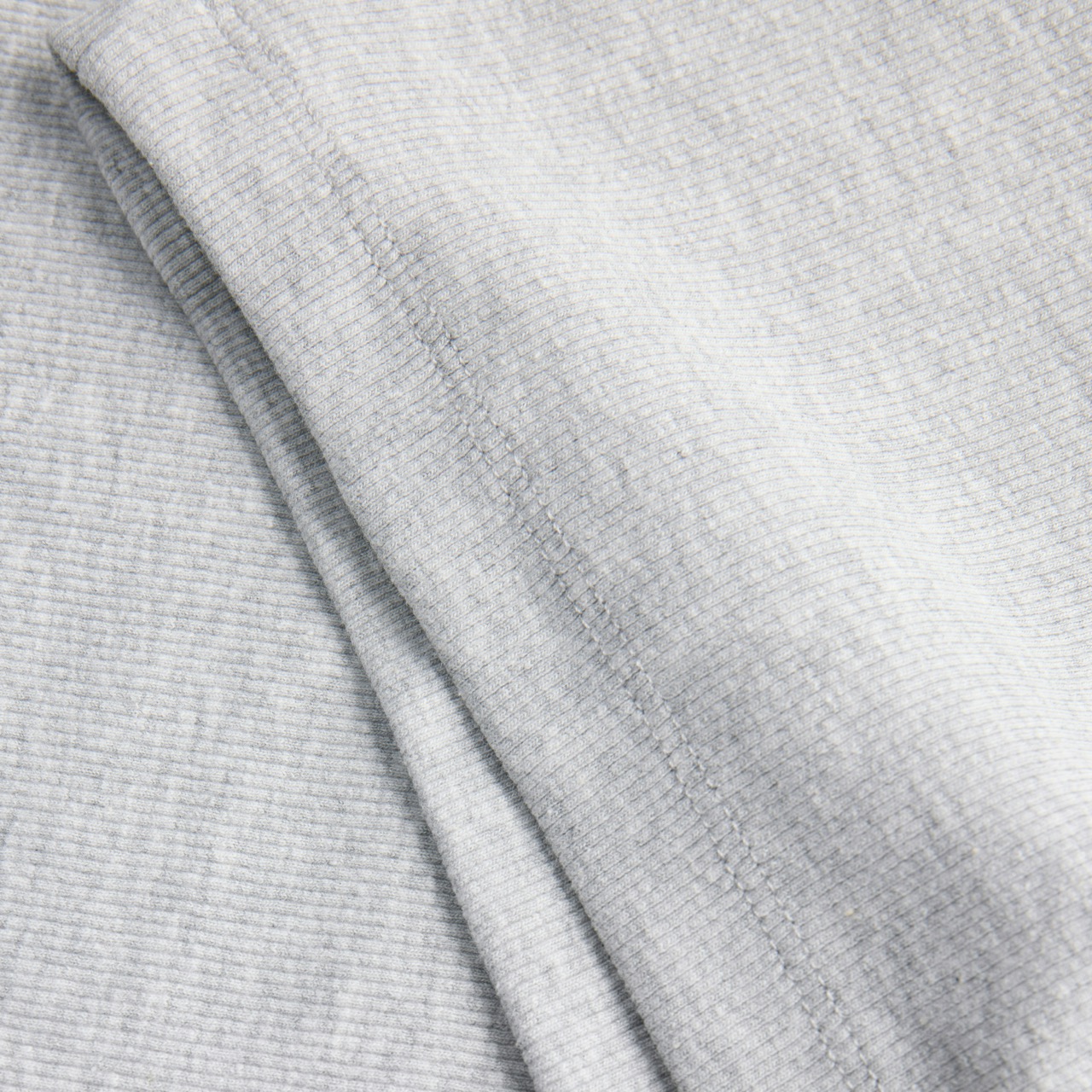 Tecido cinza claro canelado com costura visível