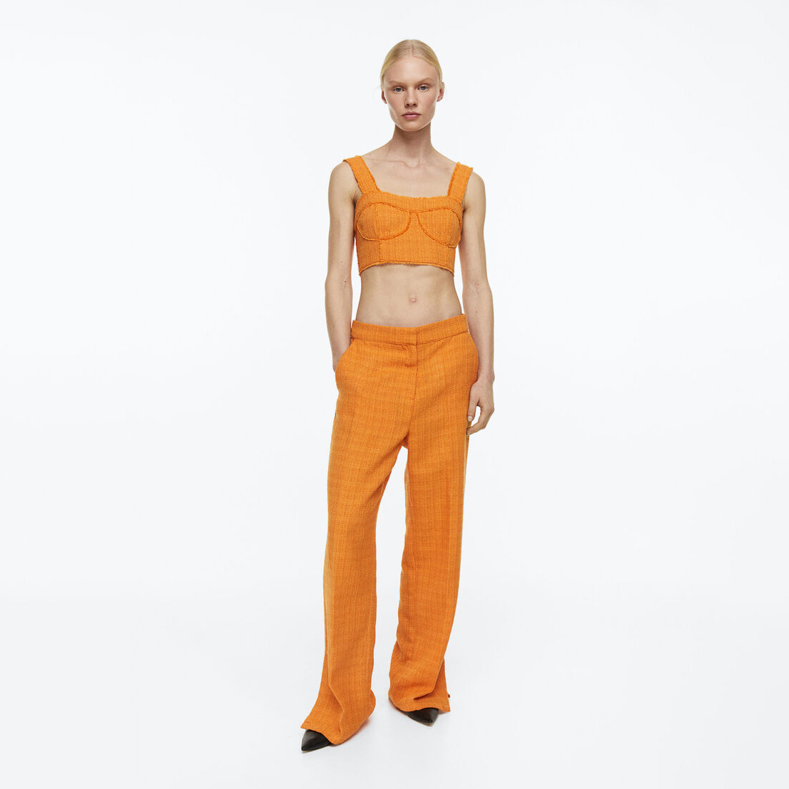 Conjunto feminino laranja com top cropped e calças largas, sapatos pretos
