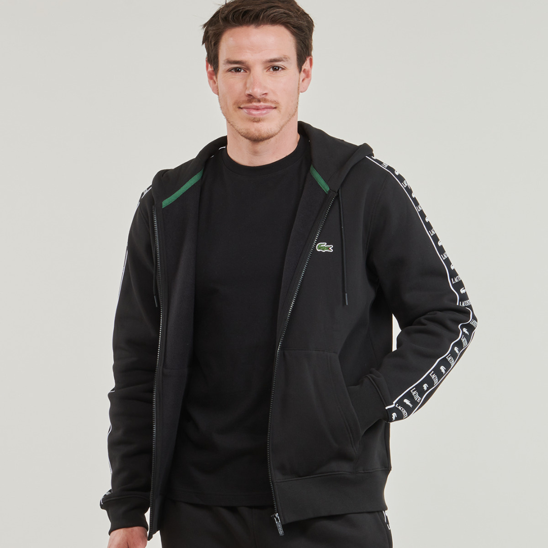 Casaco desportivo preto com capuz e fecho de correr, faixa branca com letras nas mangas, logótipo crocodilo verde e branco no peito.