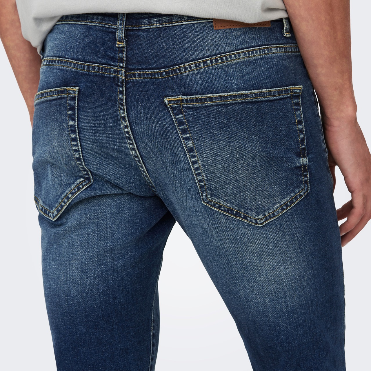 Calças de ganga azuis vistas de trás com bolsos quadrados