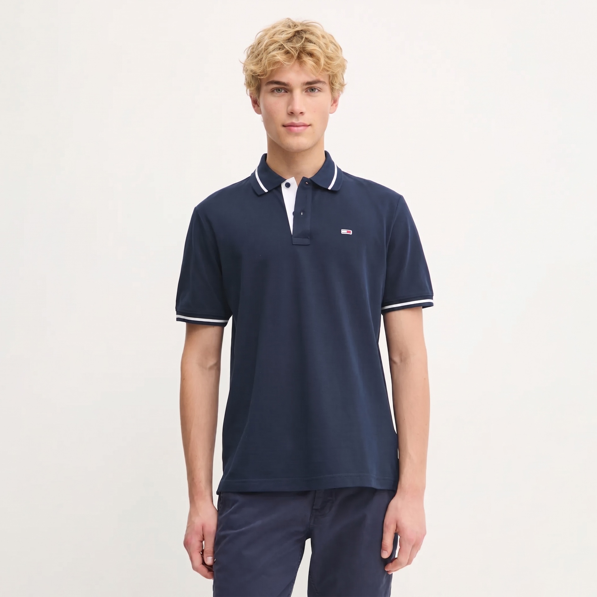 Polo azul escuro com gola e pequenos detalhes brancos e logo no peito