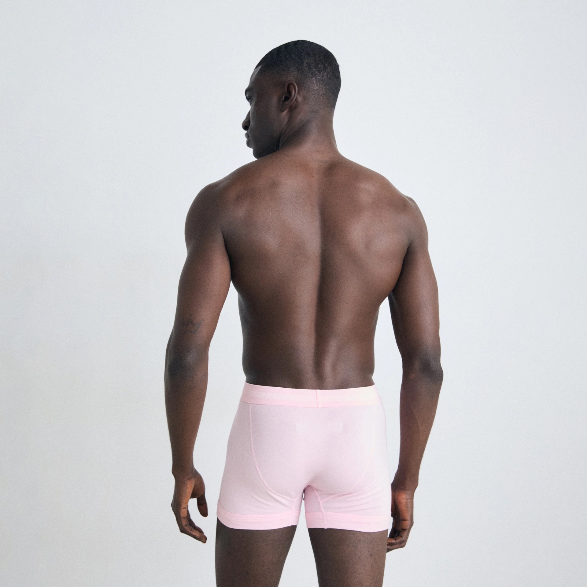 Homem de costas com boxers cor-de-rosa claros
